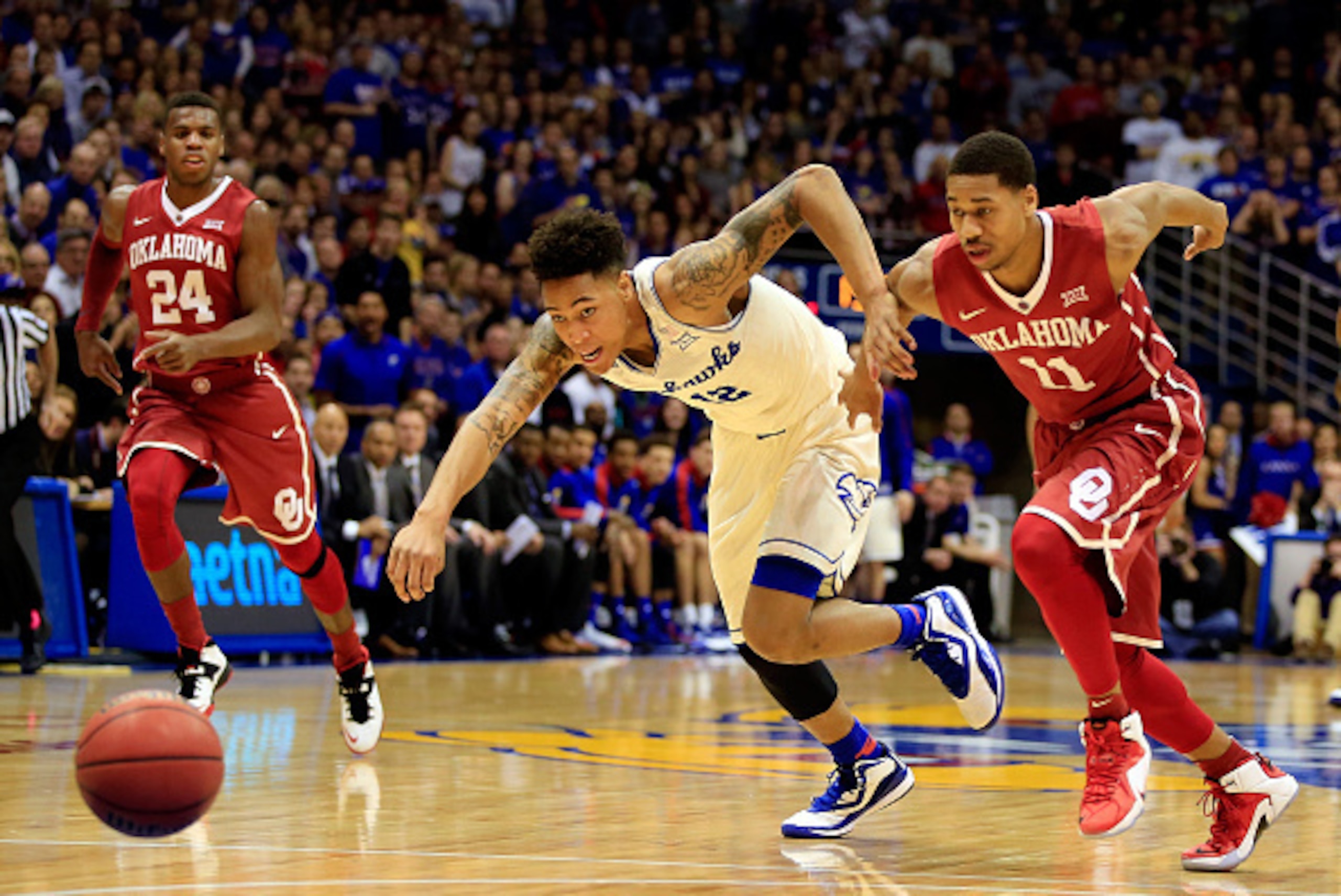 LAWRENCE, KS - JANUARY 19:  Kelly Oubre Jr. #12 of the Kansas Jayhawks battles Isaiah Cousins #11 of the Oklahoma Sooners for a loose ball during the game at Allen Fieldhouse on January 19, 2015 in Lawrence, Kansas.  (Photo by Jamie Squire/Getty Images)