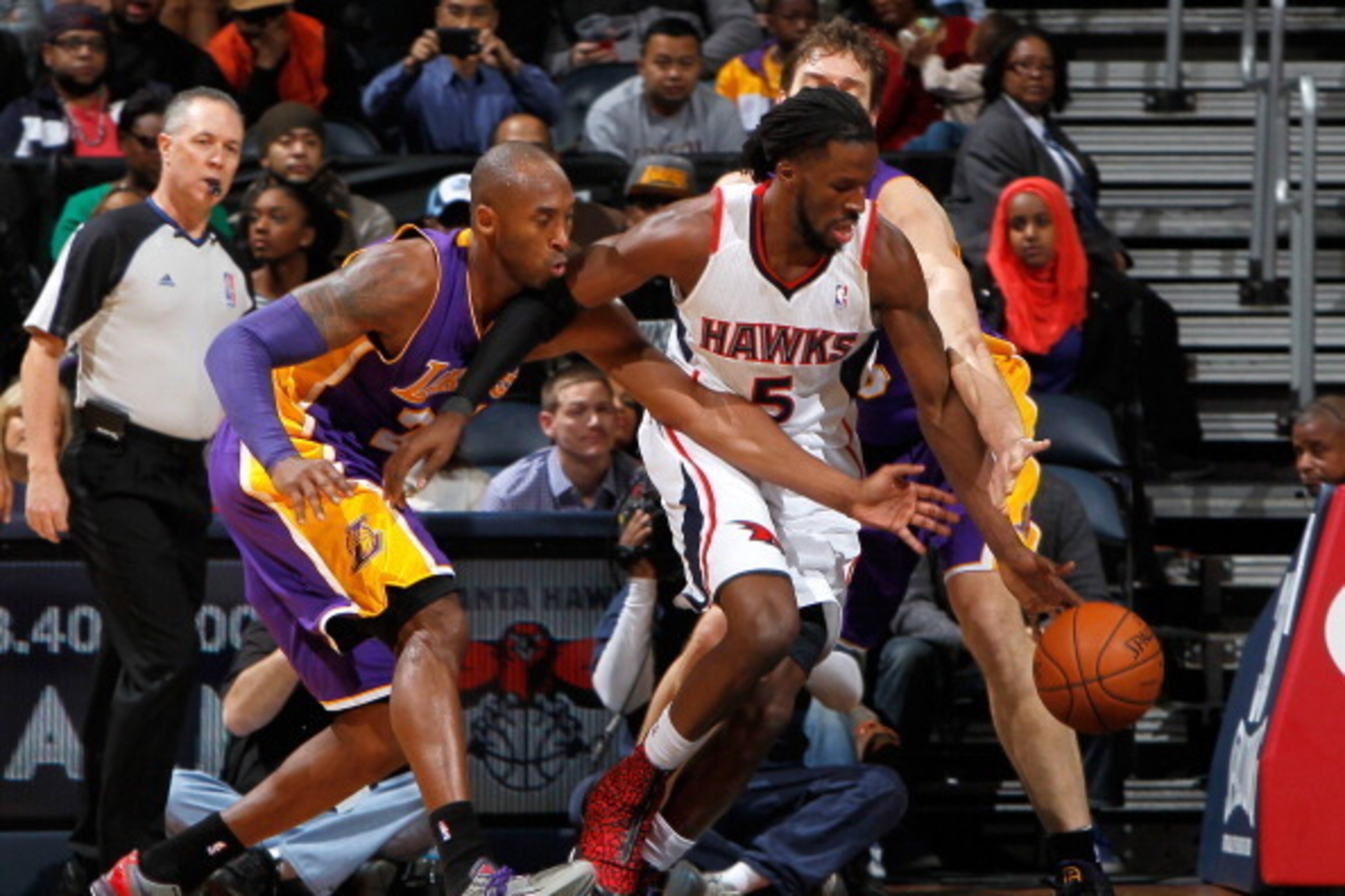 ATLANTA, GA - DECEMBER 16:  Kobe Bryant #24, and Pau Gasol #16 of the Los Angeles Lakers reach for a steal against DeMarre Carroll #5 of the Atlanta Hawks at Philips Arena on December 16, 2013 in Atlanta, Georgia.  NOTE TO USER: User expressly acknowledge