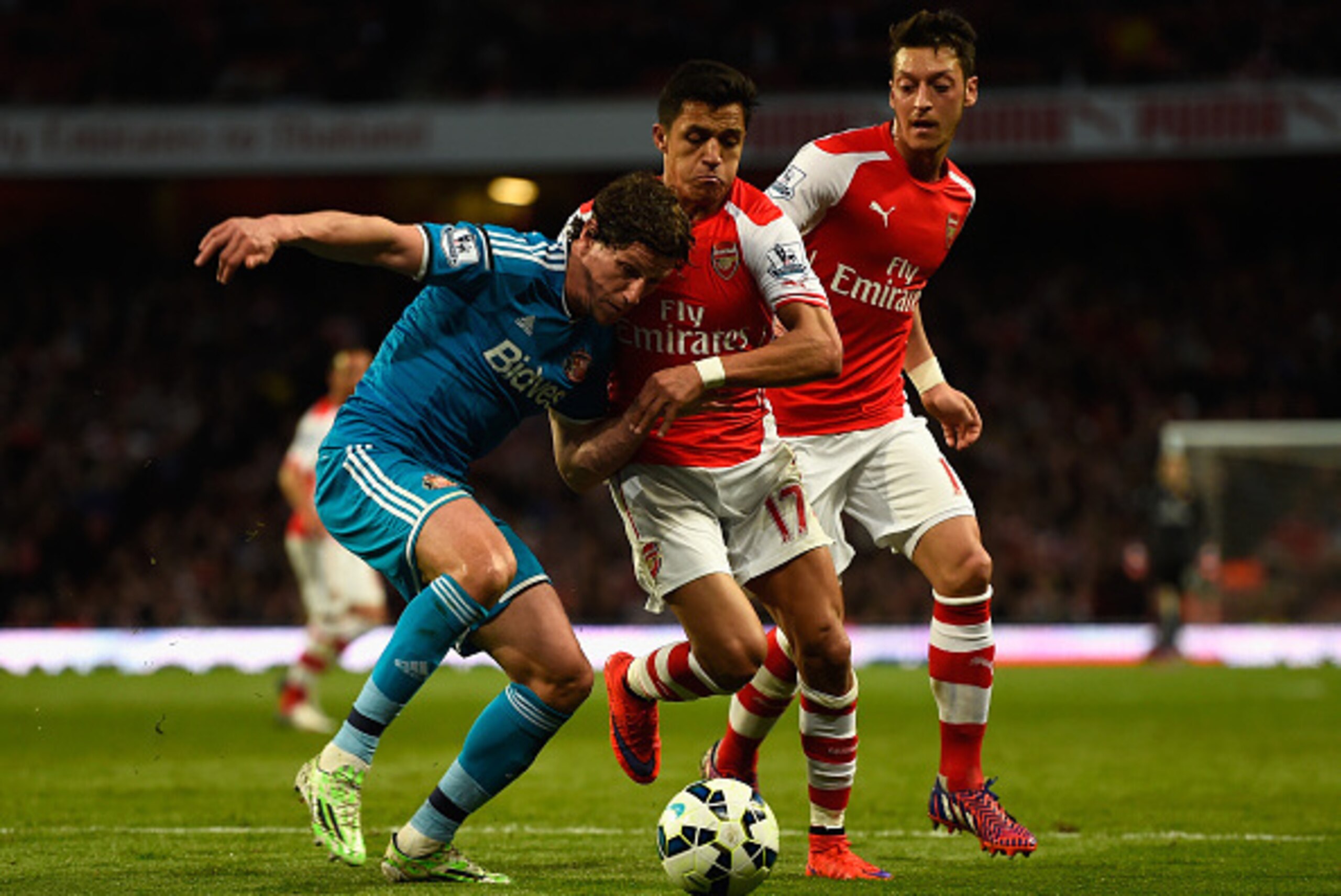 LONDON, ENGLAND - MAY 20: Billy Jones of Sunderland holds off Alexis Sanchez and Mesut Oezil of Arsenal during the Barclays Premier League match between Arsenal and Sunderland at Emirates Stadium on May 20, 2015 in London, England.  (Photo by Mike Hewitt/