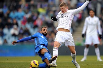 GETAFE, SPAIN - JANUARY 18:  Toni Kroos of Real Madrid is tackled by Diego Castro of Getafe CF during the La Liga match between Getafe CF and Real Madrid CF at Coliseum Alfonso Perez stadium on January 18, 2015 in Getafe, Spain.  (Photo by Denis Doyle/Get