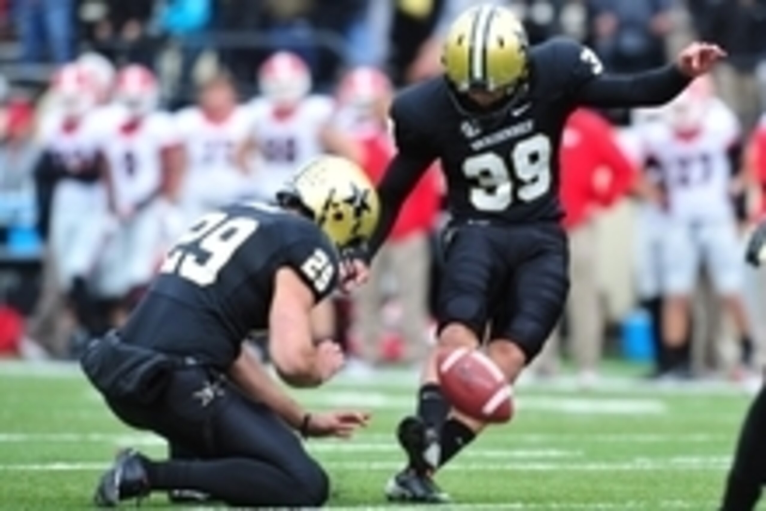 Oct 19, 2013; Nashville, TN, USA; Vanderbilt Commodores kicker Carey Spear (39) kicks an extra point while punter Taylor Hudson (29) holds against the Georgia Bulldogs during the second half at Vanderbilt Stadium. The Commodores beat the Bulldogs 31-27. M
