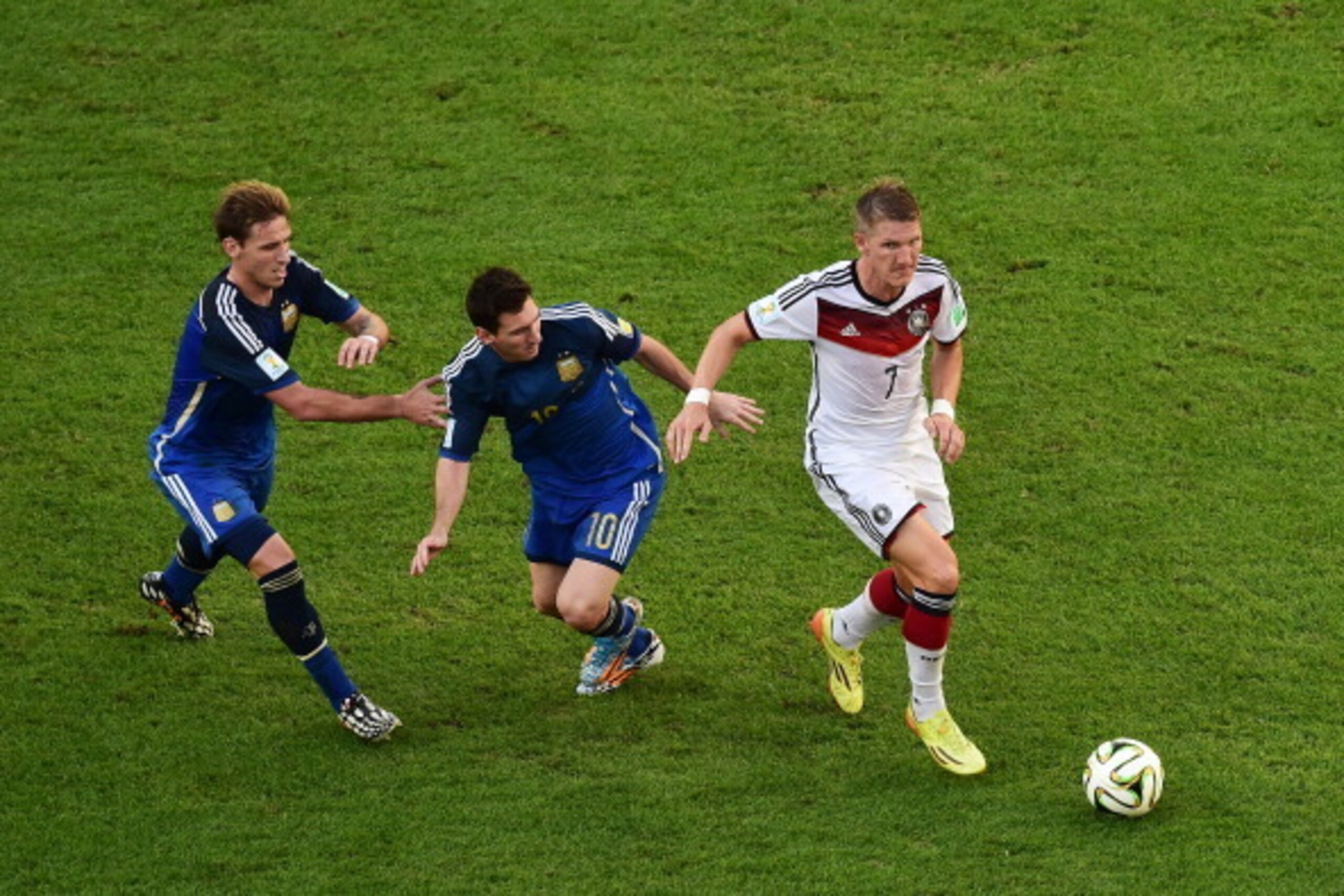 RIO DE JANEIRO, BRAZIL - JULY 13: Bastian Schweinsteiger of Germany controls the ball against Lucas Biglia (L) and Lionel Messi of Argentina during the 2014 FIFA World Cup Brazil Final match between Germany and Argentina at Maracana on July 13, 2014 in Ri