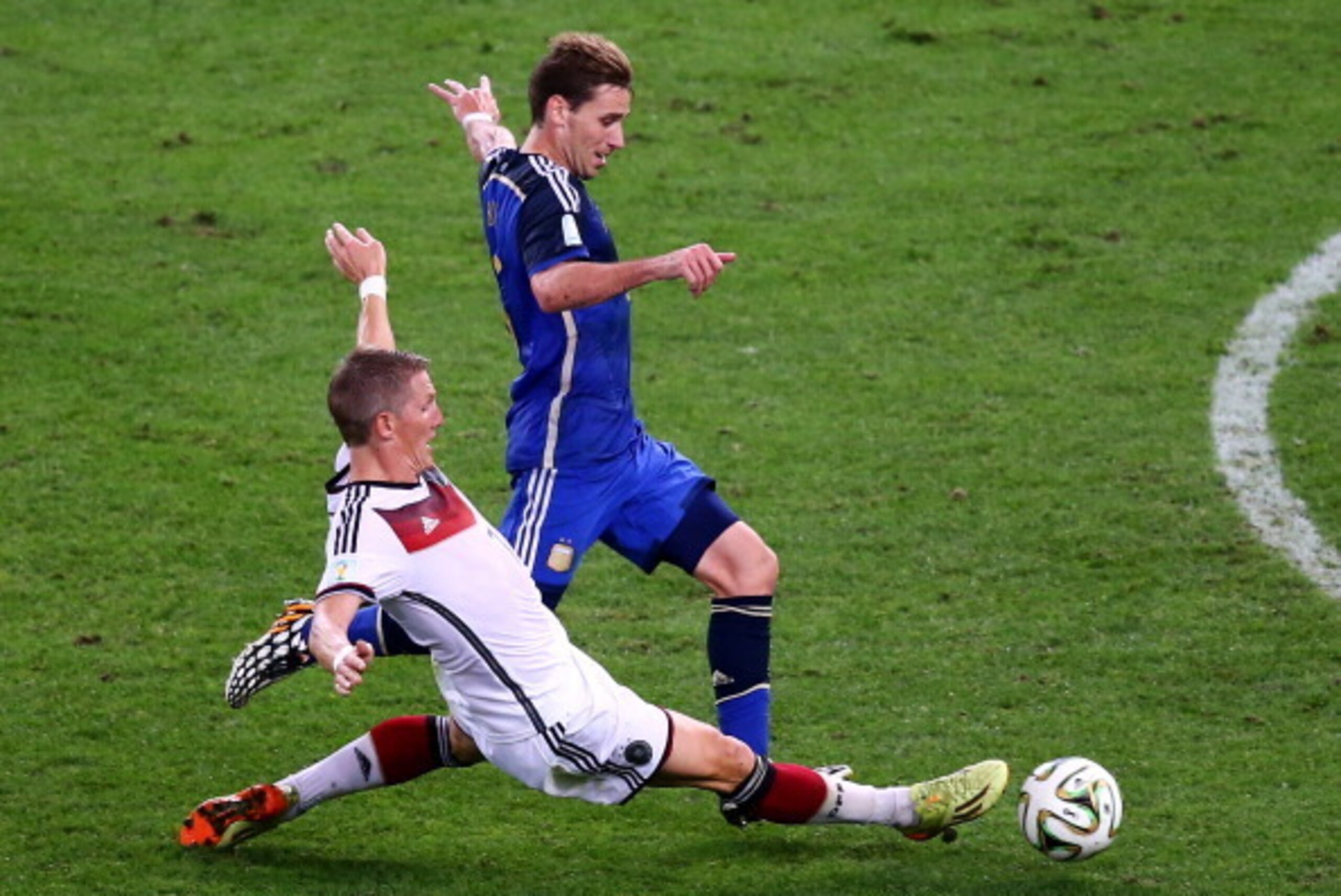 RIO DE JANEIRO, BRAZIL - JULY 13: Bastian Schweinsteiger of Germany tackles Lucas Biglia of Argentina during the 2014 FIFA World Cup Brazil Final match between Germany and Argentina at Maracana on July 13, 2014 in Rio de Janeiro, Brazil. (Photo by Rober RIO DE JANEIRO, BRAZIL - JULY 13: Bastian Schweinsteiger of Germany tackles Lucas Biglia of Argentina during the 2014 FIFA World Cup Brazil Final match between Germany and Argentina at Maracana on July 13, 2014 in Rio de Janeiro, Brazil. (Photo by Rober