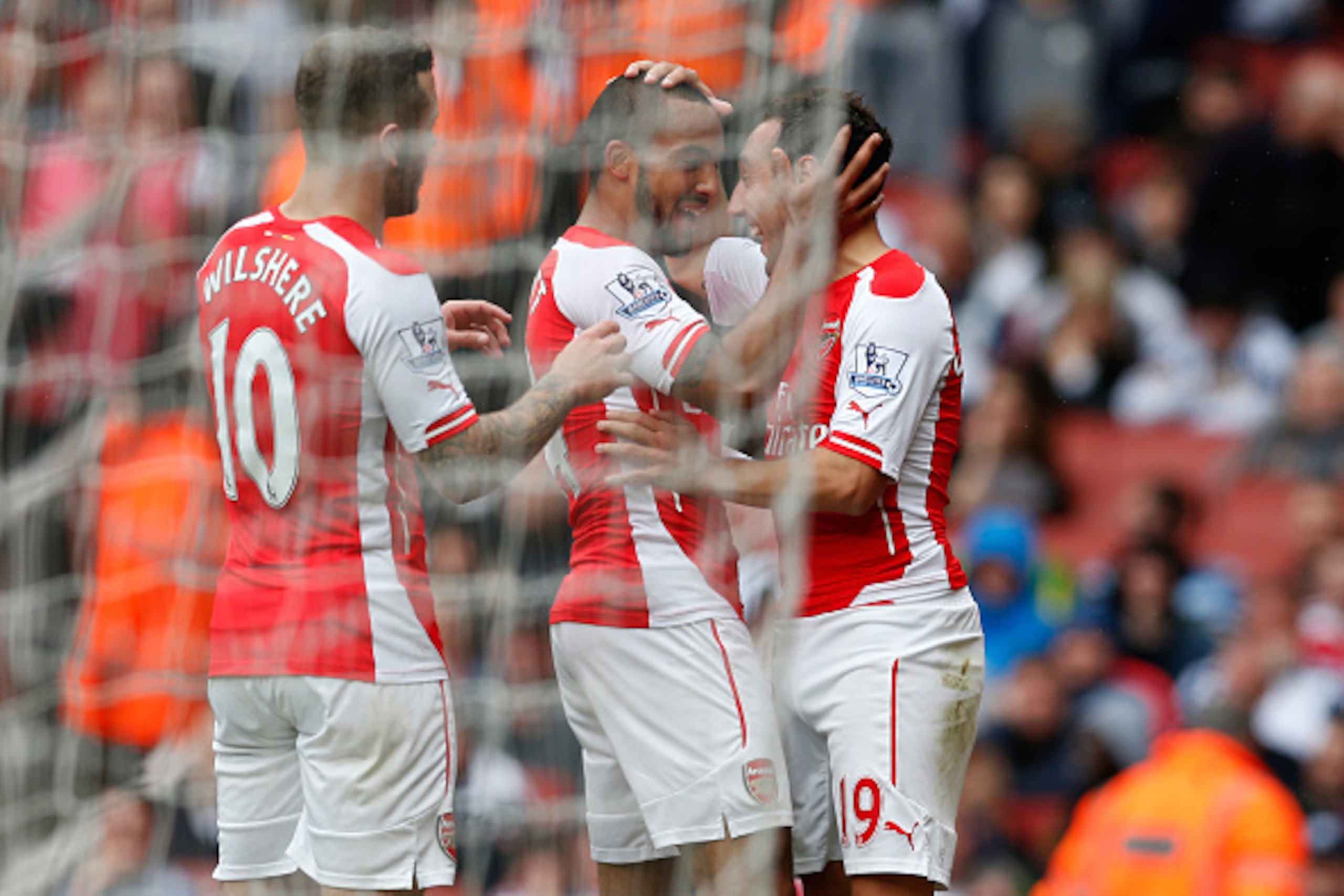 LONDON, ENGLAND - MAY 24:  Theo Walcott (C)  of Arsenal celebrates his team's fourth goal to make a hat trick with his team mate Jack Wilshere (L) and Santi Cazorla (R) during the Barclays Premier League match between Arsenal and West Bromwich Albion at E