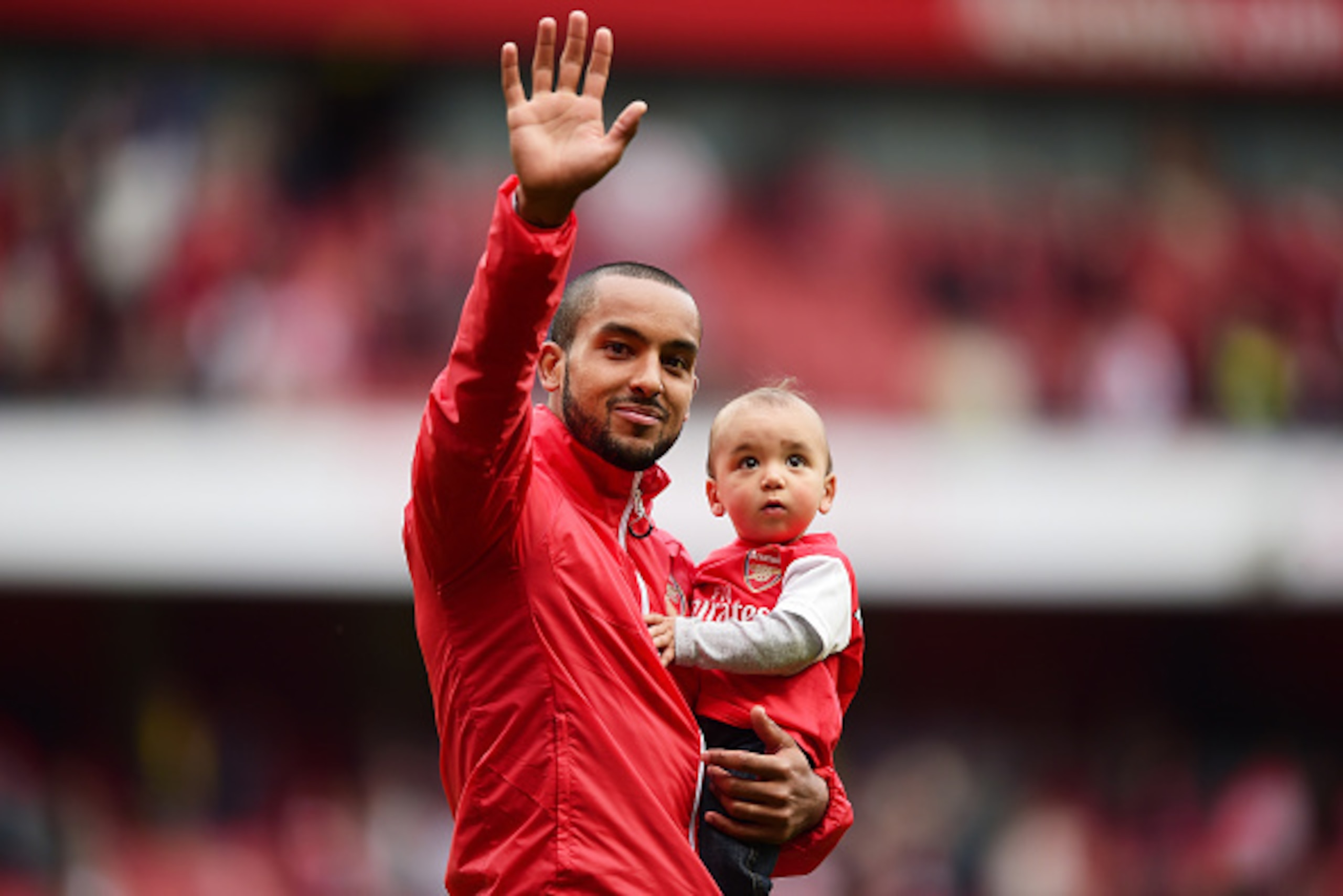 LONDON, ENGLAND - MAY 24:  Theo Walcott of Arsenal holding his children waves to supporters after the Barclays Premier League match between Arsenal and West Bromwich Albion at Emirates Stadium on May 24, 2015 in London, England.  (Photo by Jamie McDonald/