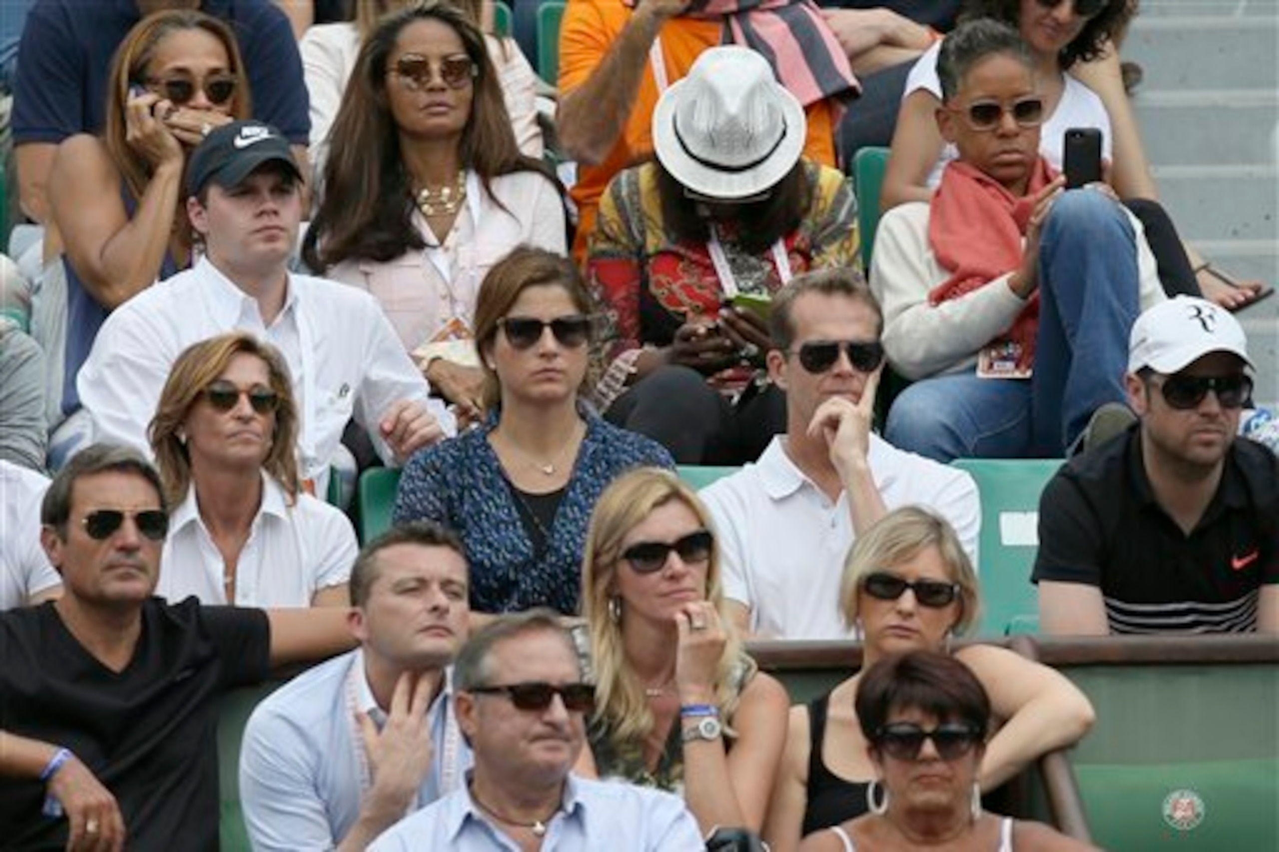 Federer's wife and coaches look on during his first-round match.
