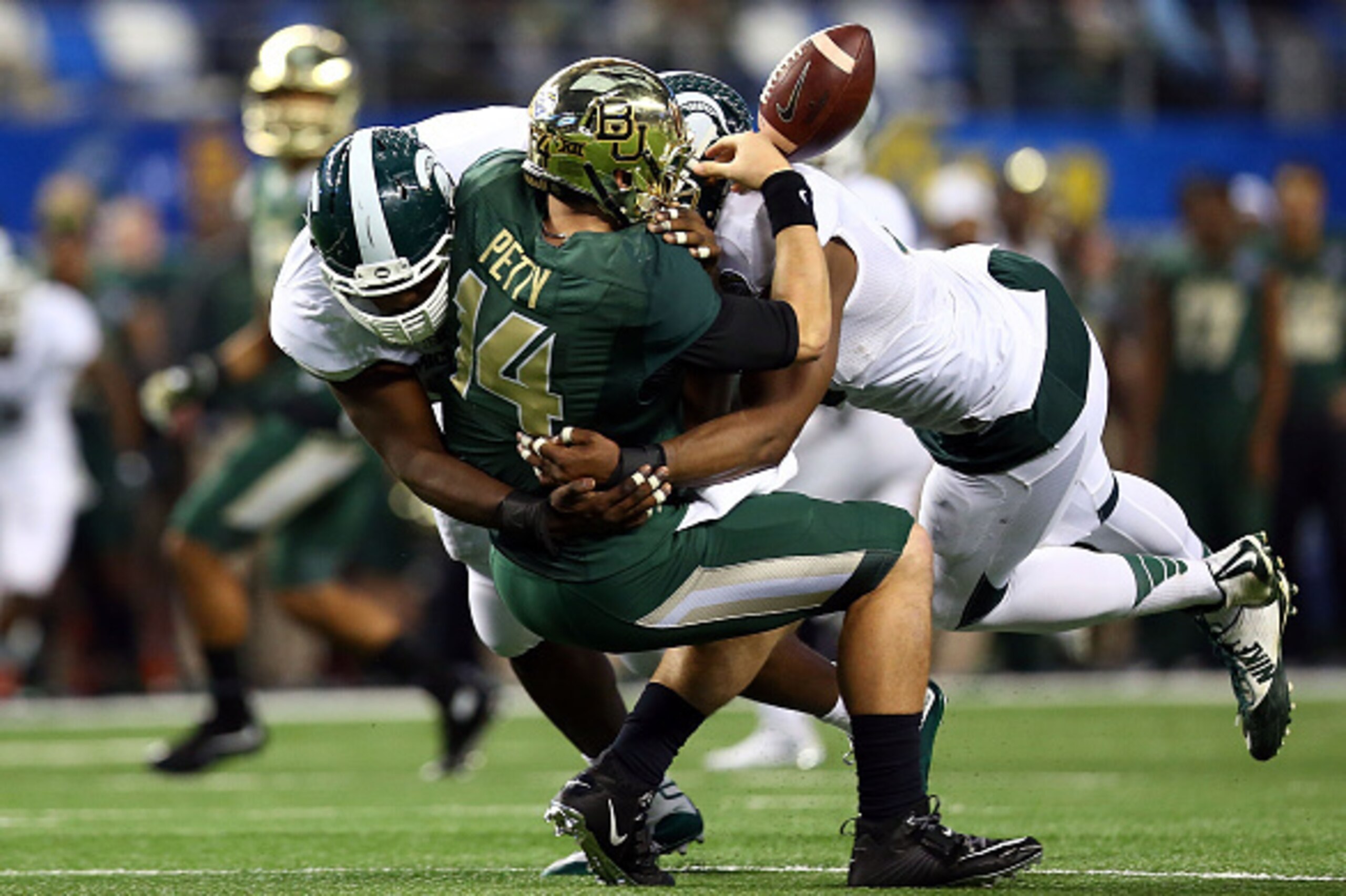 ARLINGTON, TX - JANUARY 01:  Bryce Petty #14 of the Baylor Bears fumbles as he is hit by Joel Heath #92 of the Michigan State Spartans and Shilique Calhoun #89 of the Michigan State Spartans during the second half of the Goodyear Cotton Bowl Classic at AT