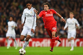 MADRID, SPAIN - NOVEMBER 04: Raphael Varane of Real Madrid CF and Lazar Markovic of Liverpool compete for the ball during the UEFA Champions League Group B match between Real Madrid CF and Liverpool FC at Estadio Santiago Bernabeu on November 4, 2014 in M