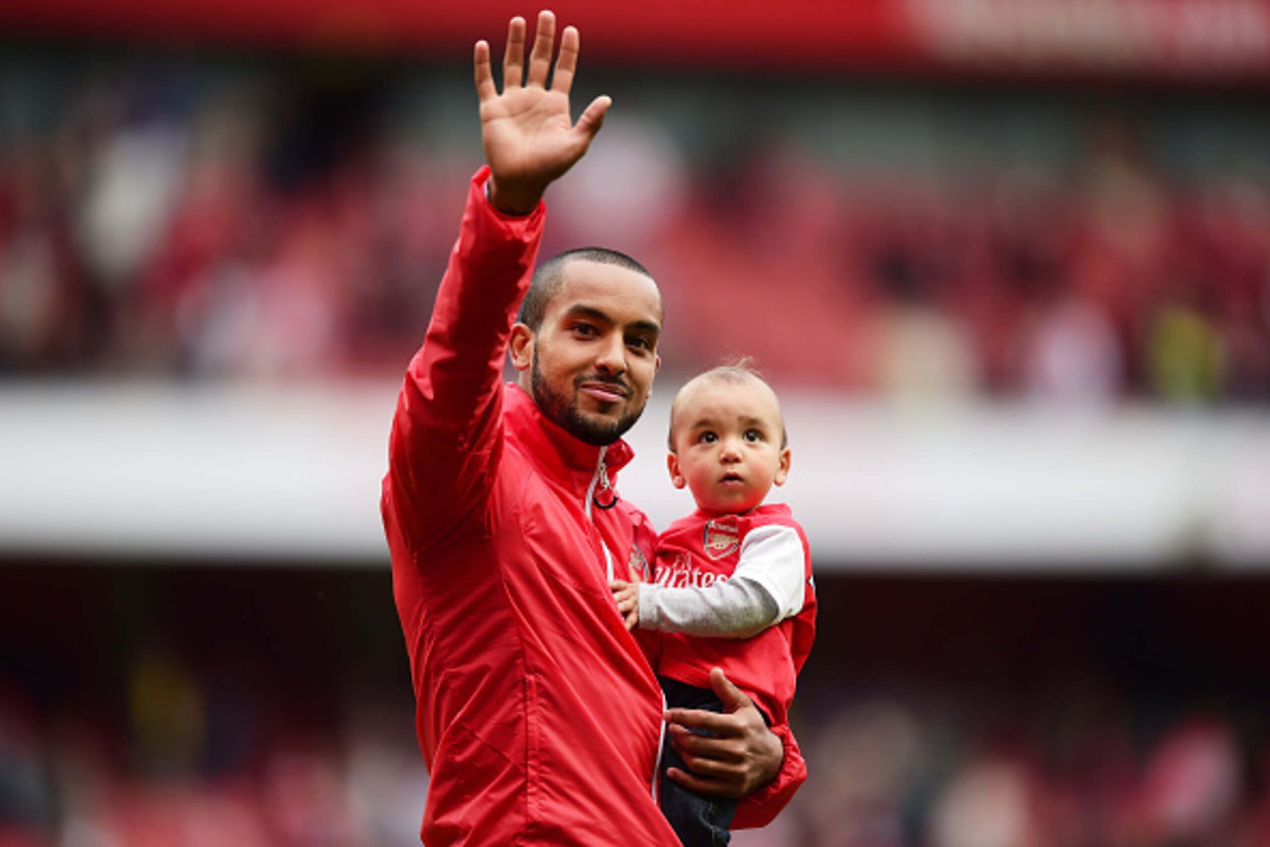 LONDON, ENGLAND - MAY 24:  Theo Walcott of Arsenal holding his children waves to supporters after the Barclays Premier League match between Arsenal and West Bromwich Albion at Emirates Stadium on May 24, 2015 in London, England.  (Photo by Jamie McDonald/