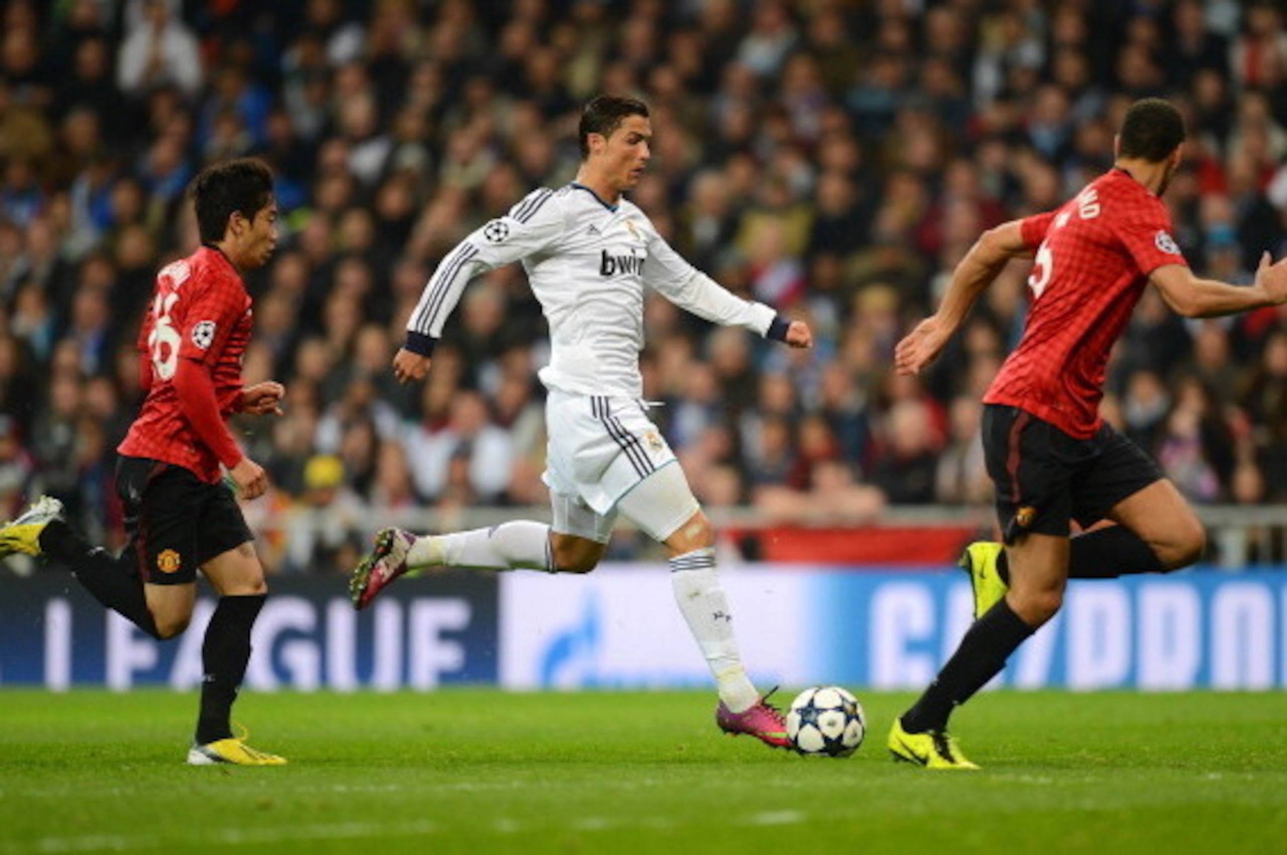MADRID, SPAIN - FEBRUARY 13:  Cristiano Ronaldo of Real Madrid is marshalled by Shinji Kagawa of Manchester United and Rio Ferdinand of Manchester United during the UEFA Champions League Round of 16 first leg match between Real Madrid and Manchester Unite