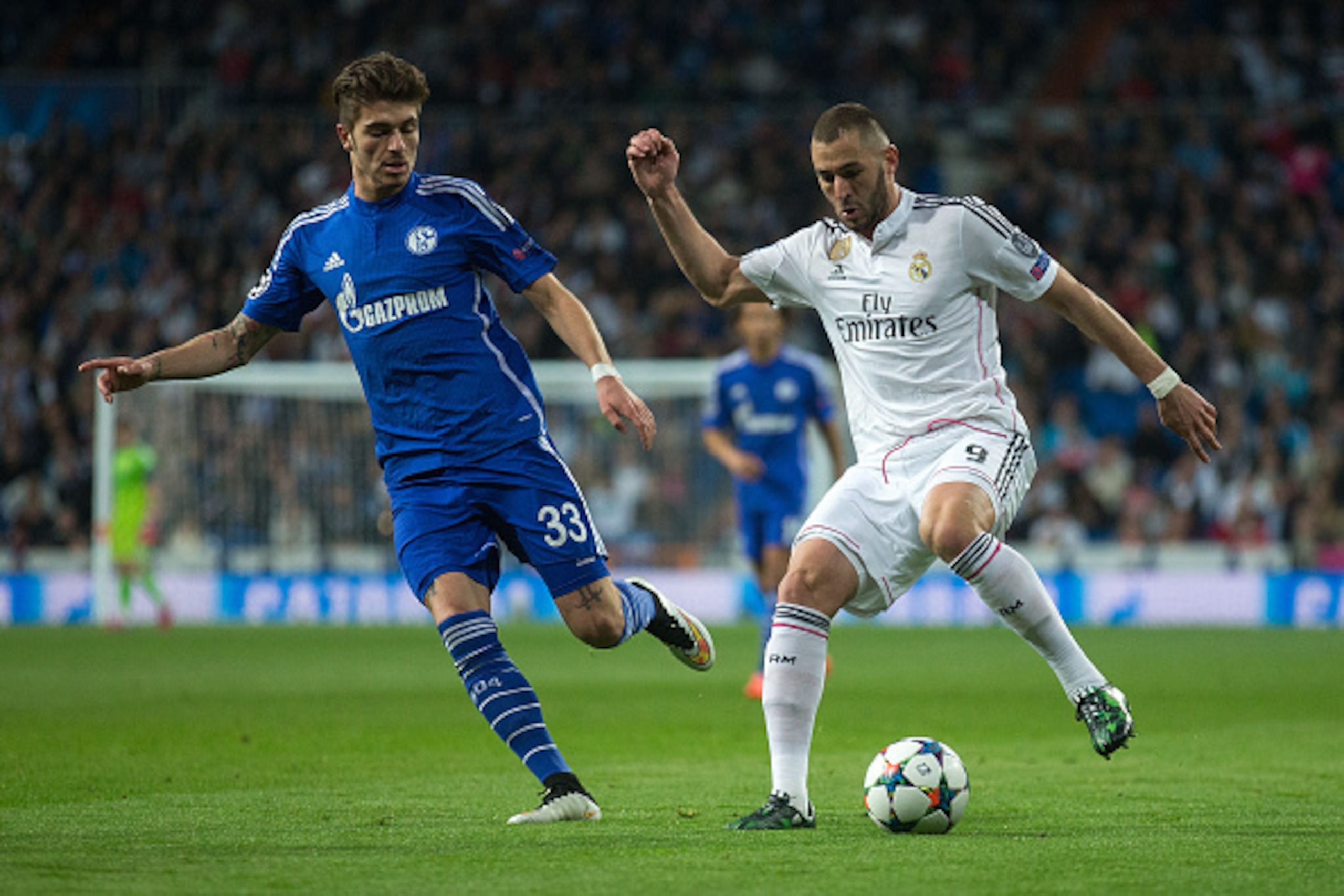 MADRID, SPAIN - MARCH 10: Karim Benzema (R) of Real Madrid CF competes for the ball with Roman Neustadter (L) of FC Schalke 04 during the UEFA Champions League round of 16 second leg match between Real Madrid CF and FC Schalke 04 at Estadio Santiago Berna