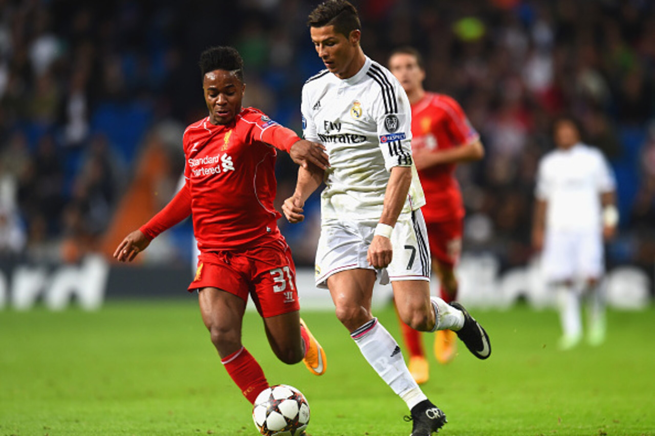 MADRID, SPAIN - NOVEMBER 04:  Raheem Sterling of Liverpool and Cristiano Ronaldo of Real Madrid CF battle for the ball during the UEFA Champions League Group B match between Real Madrid CF and Liverpool FC at Estadio Santiago Bernabeu on November 4, 2014 