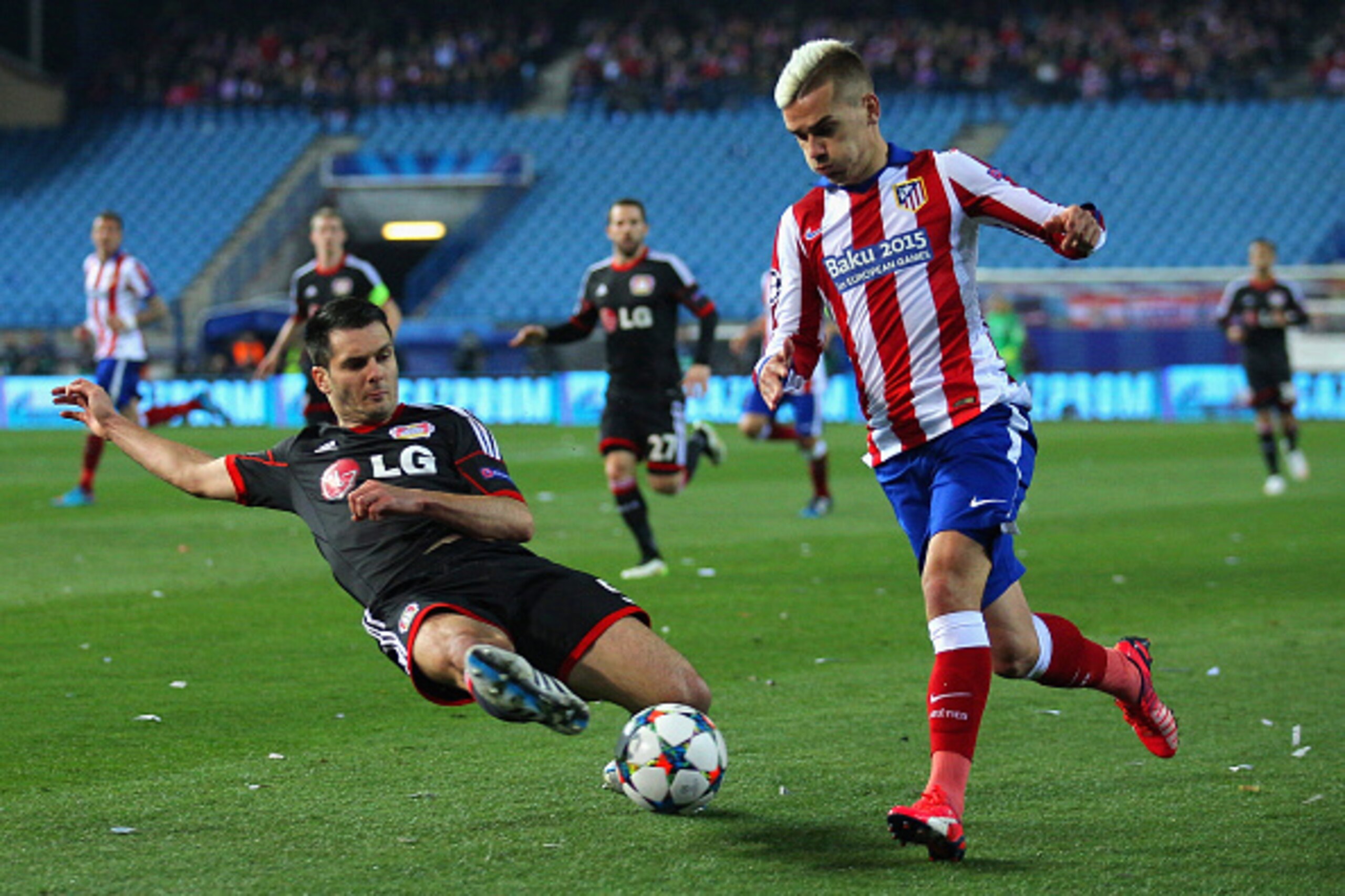 MADRID, SPAIN - MARCH 17:  Antoine Griezmann of Atletico Madrid leaps over the challenge from Emir Spahic of Bayer Leverkusen during the UEFA Champions League round of 16 match between Club Atletico de Madrid and Bayer 04 Leverkusen at Vicente Calderon St