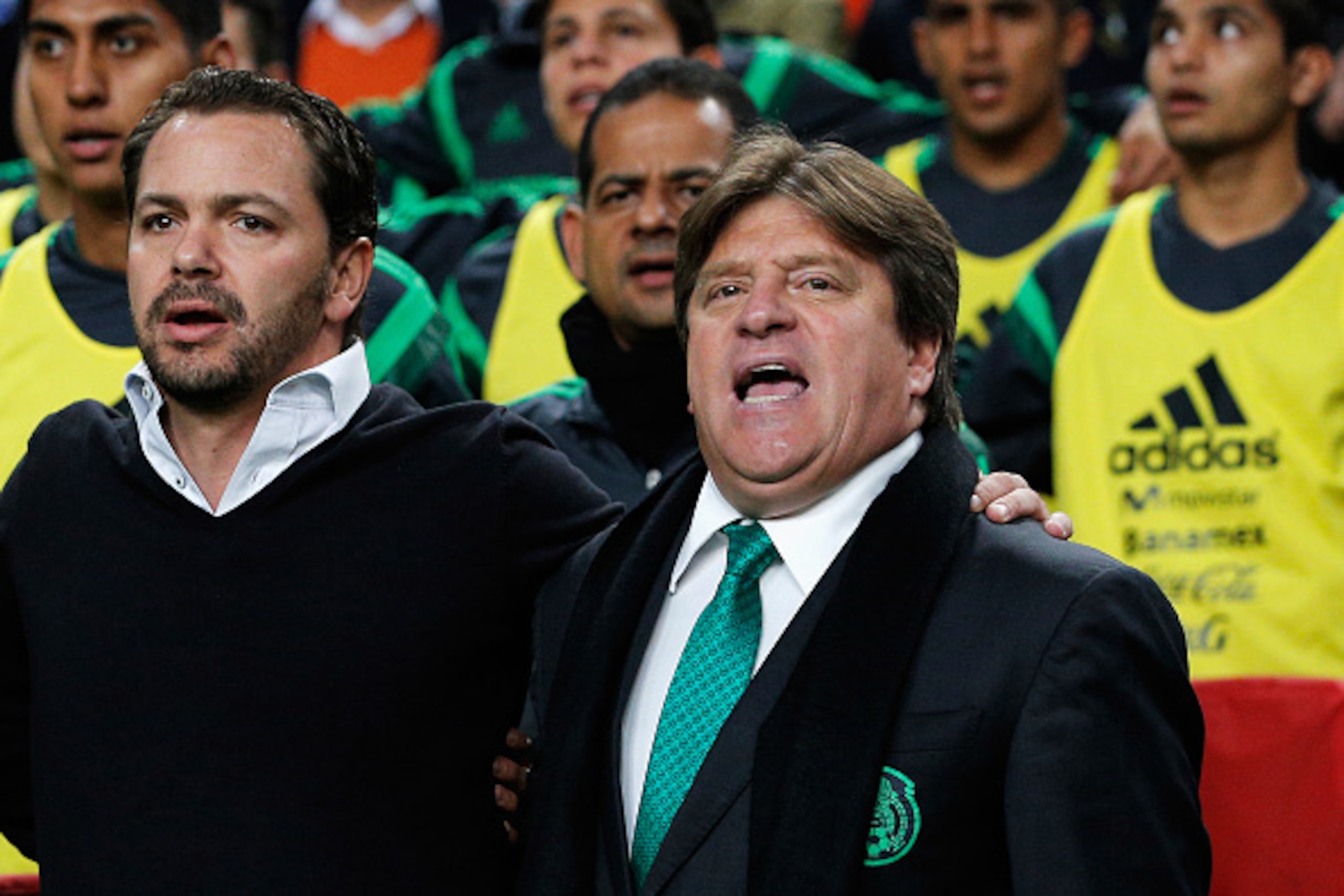 AMSTERDAM, NETHERLANDS - NOVEMBER 12:  Mexico Head Coach / Manager, Miguel Herrera (R) and his staff sing the national anthem prior to the international friendly match between Netherlands and Mexico held at the Amsterdam ArenA on November 12, 2014 in Amst