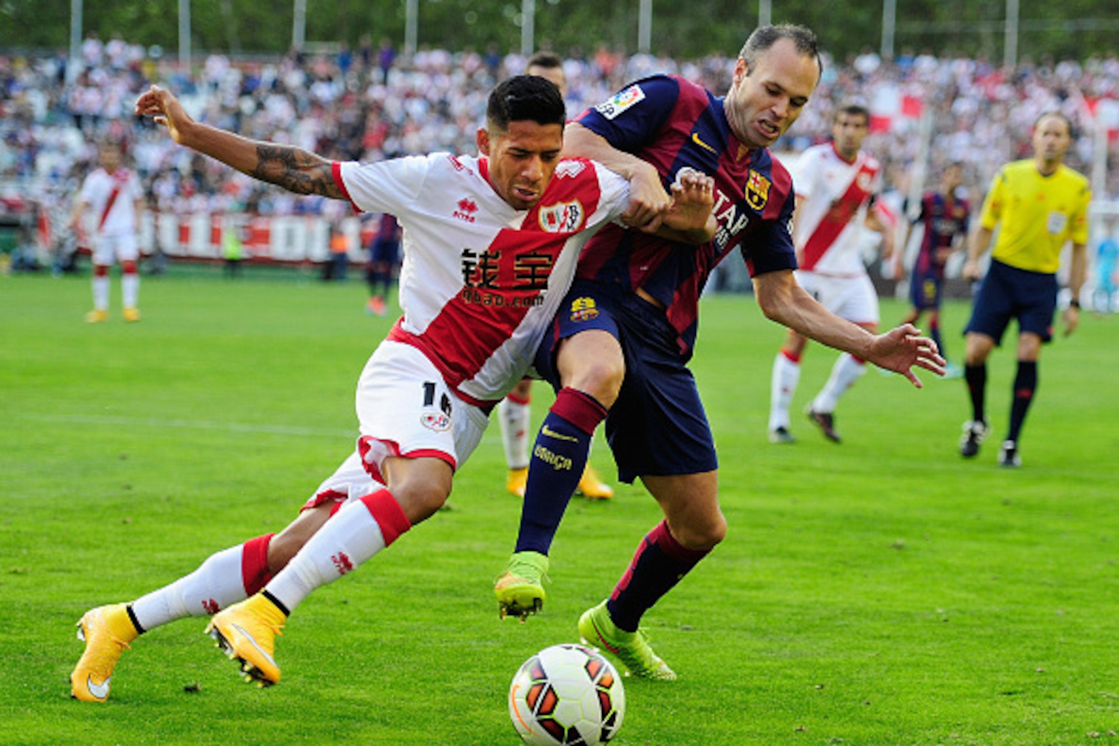 MADRID, SPAIN - OCTOBER 04:  Andres Iniesta of FC Barcelona is tackled by Javier Ignacio Aquino of Rayo Vallecano de Madrid during the La Liga match between Rayo Vallecano de Madrid and FC Barcelona at Estadio Teresa Rivero on October 4, 2014 in Madrid, S