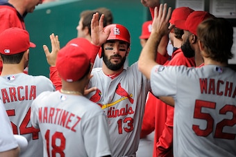 KANSAS CITY, MO - MAY 24:  Matt Carpenter #13 of the St. Louis Cardinals celebrates with teammates after scoring on a Matt Adams double in the first inning during a game against the Kansas City Royals at Kauffman Stadium on May 24, 2015 in Kansas City, Mi