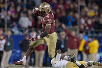 CHARLOTTE, NC - DECEMBER 06:  Dalvin Cook #4 of the Florida State Seminoles breaks away from Jamal Golden #4 of the Georgia Tech Yellow Jackets during the Atlantic Coast Conference championship game on December 6, 2014 in Greenville, North Carolina. Flori
