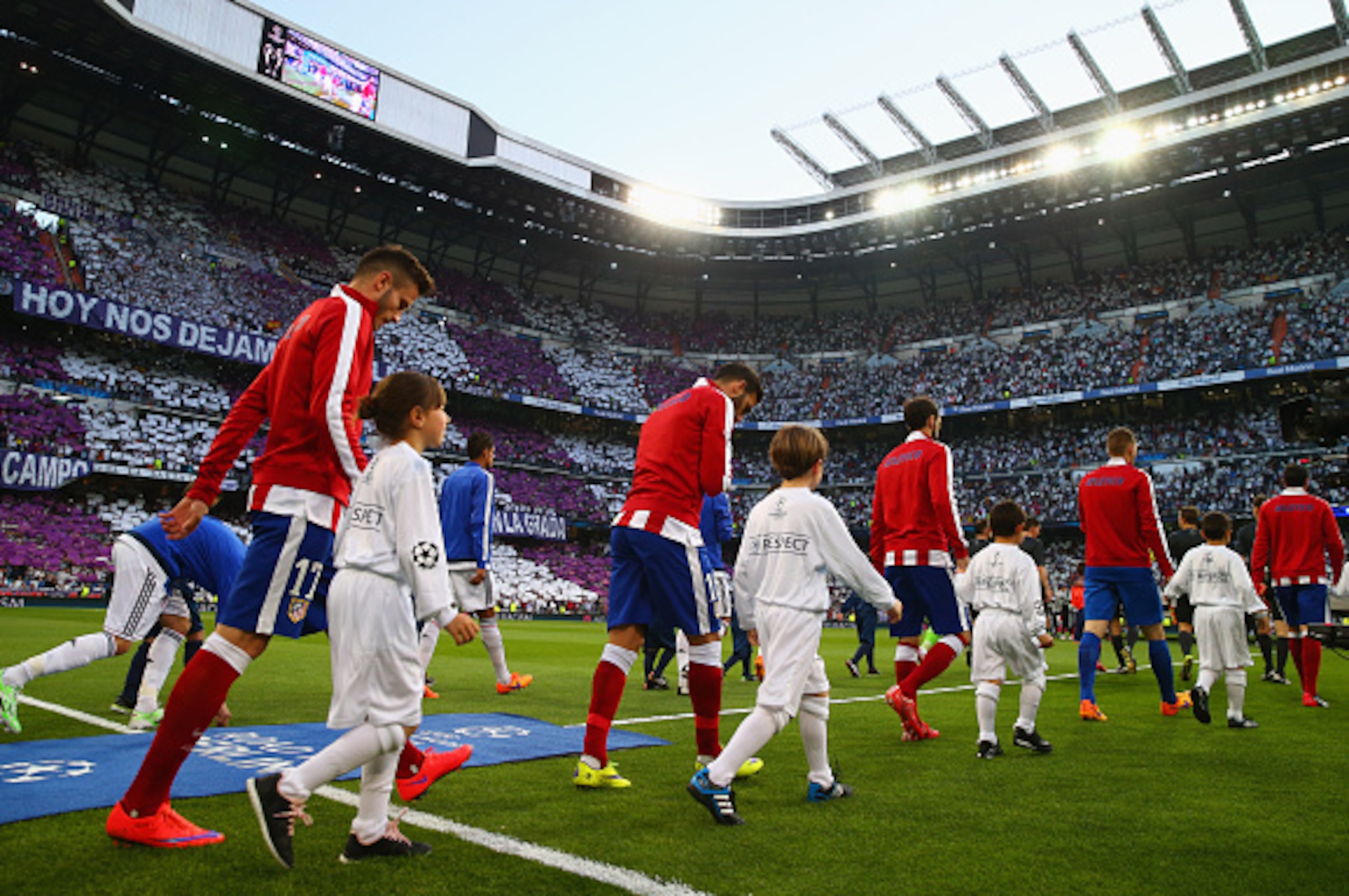 MADRID, SPAIN - APRIL 22:  Players walk onto the pitch prior to the UEFA Champions League quarter-final second leg match between Real Madrid CF and Club Atletico de Madrid at Bernabeu on April 22, 2015 in Madrid, Spain.  (Photo by Clive Rose/Getty Images)