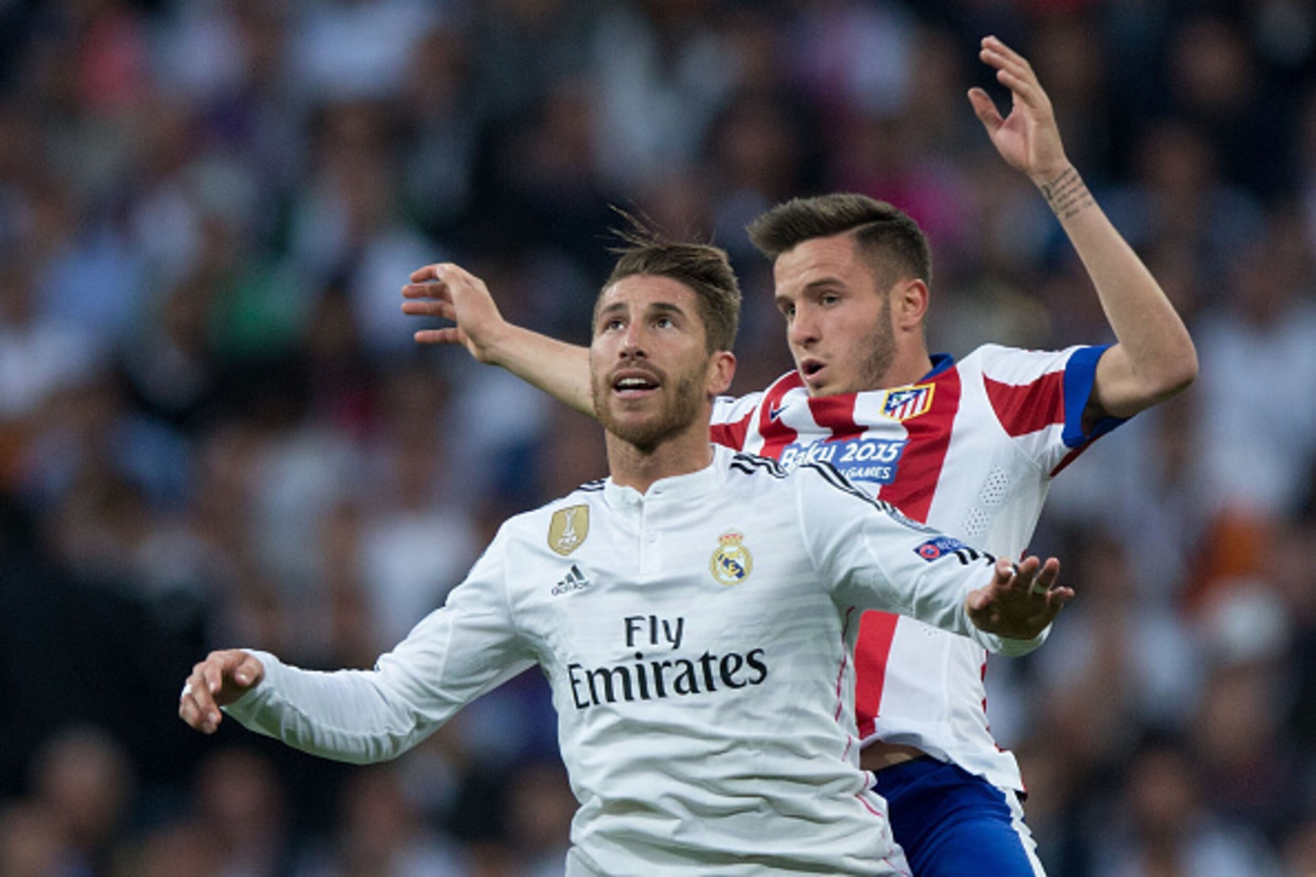 MADRID, SPAIN - APRIL 22: Sergio Ramos of Real Madrid CF jumps for the ball ahead Saul Niguez of Atletico de Madrid during the UEFA Champions League quarter-final second leg match between Real Madrid CF and Club Atletico de Madrid at Bernabeu on April 22,