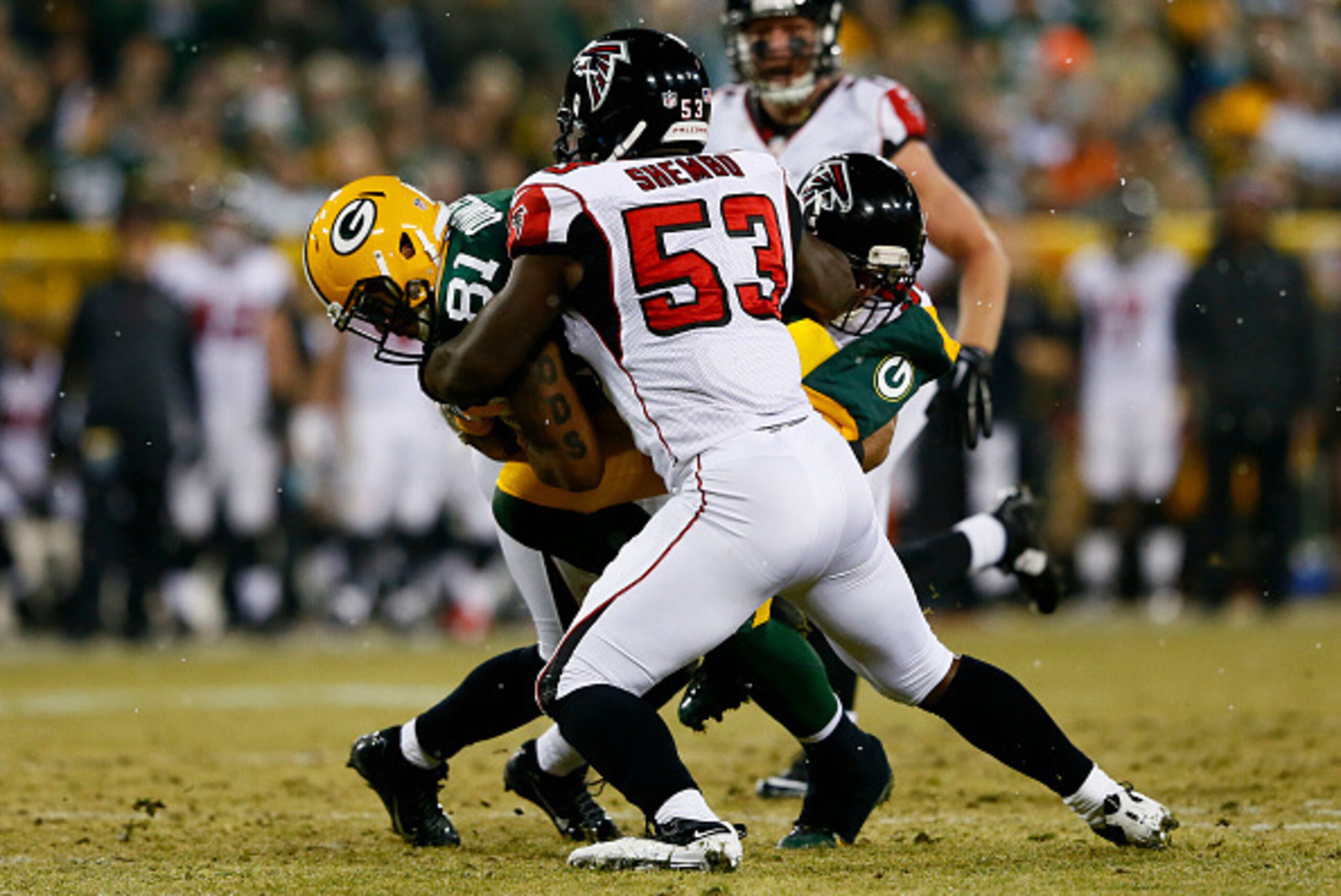 GREEN BAY, WI - DECEMBER 08:   Andrew Quarless #81 of the Green Bay Packers is tackled by  Prince Shembo #53 and  Paul Worrilow #55 of the Atlanta Falcons in the first half at Lambeau Field on December 8, 2014 in Green Bay, Wisconsin.  (Photo by Kevin C. 
