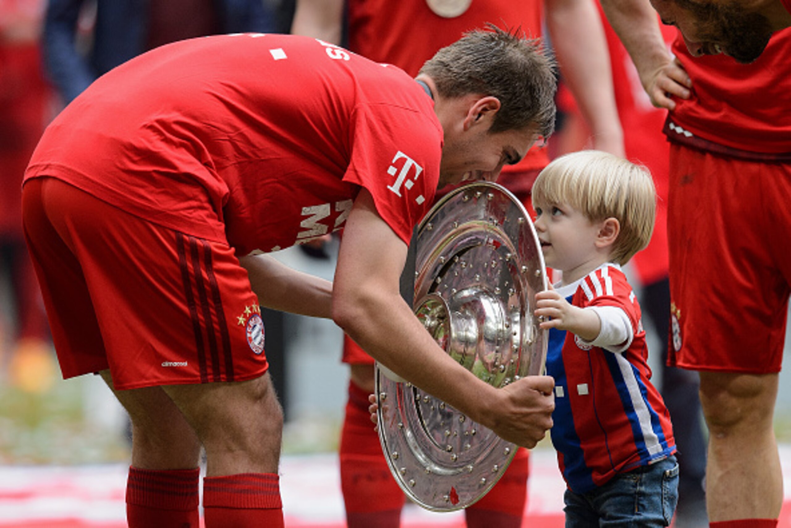 MUNICH, GERMANY - MAY 23:  Philipp Lahm of Muenchen presents the Bundesliga trophy to his son Julian after winning the league during the Bundesliga match between FC Bayern Muenchen and 1. FSV Mainz 05 at Allianz Arena on May 23, 2015 in Munich, Germany.  
