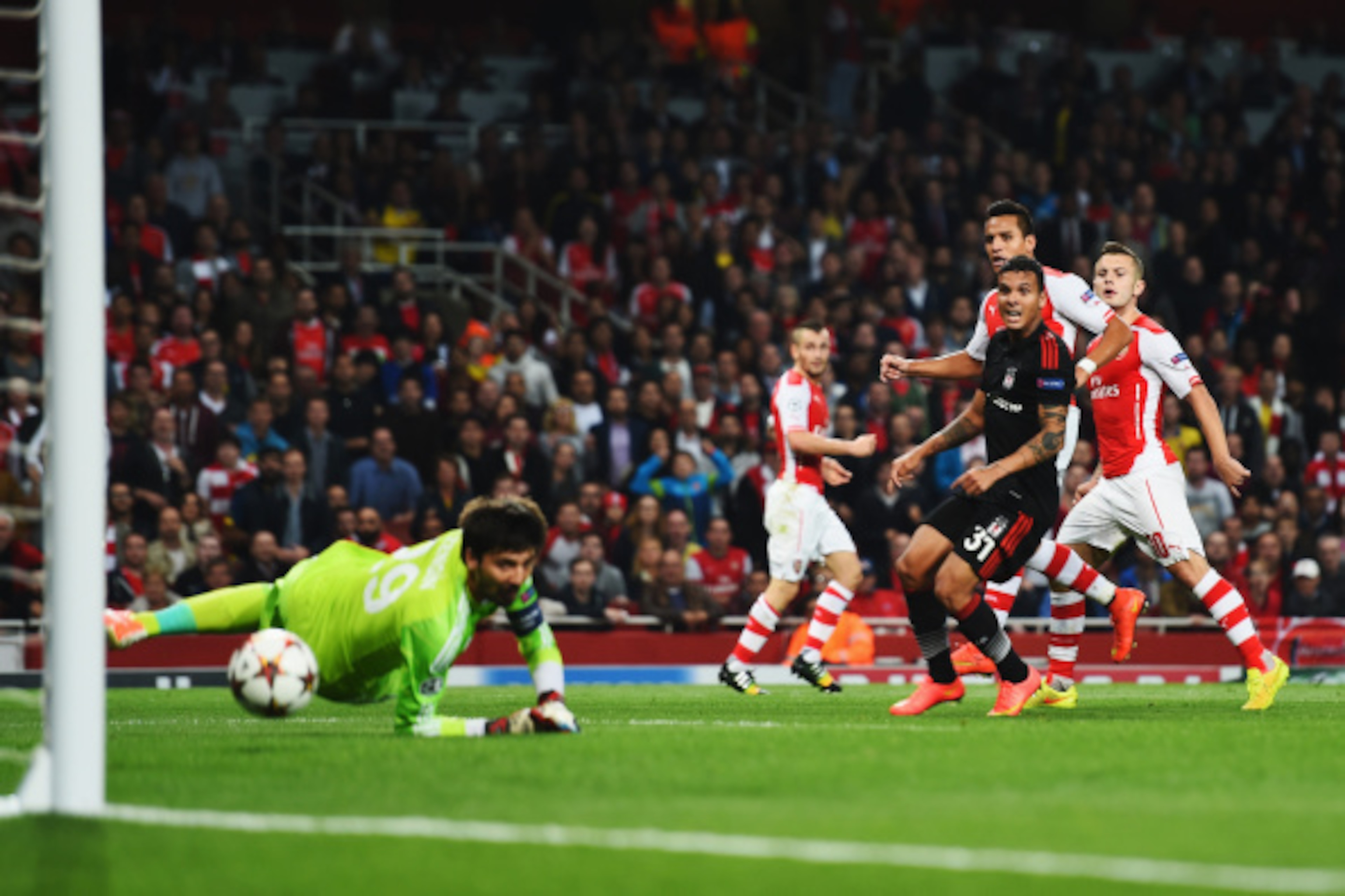 LONDON, ENGLAND - AUGUST 27: Alexis Sanchez (2nd right) of Arsenal shoots and scores past Tolga Zengin the Besiktas goalkeeper during the UEFA Champions League Qualifier 2nd leg match between Arsenal and Besiktas at the Emirates Stadium on August 27, 2014