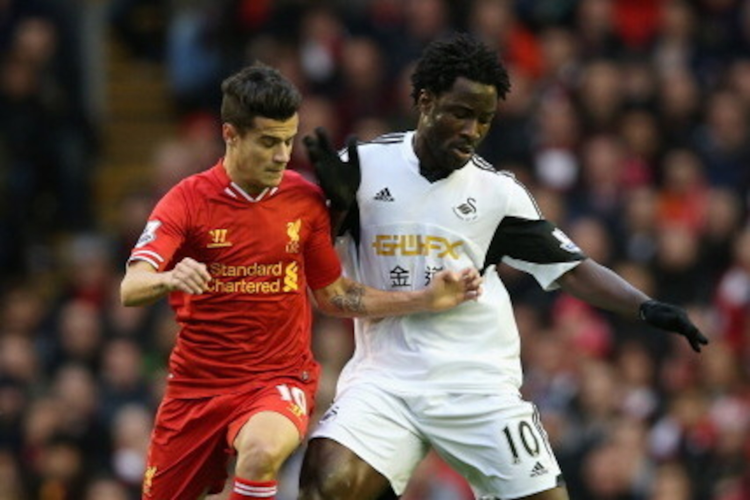 LIVERPOOL, ENGLAND - FEBRUARY 23:  Philippe Coutinho of Liverpool competes with Wilfried Bony of Swansea City during the Barclays Premier League match between Liverpool and Swansea City at Anfield on February 23, 2014 in Liverpool, England.  (Photo by Cli