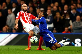 LONDON, ENGLAND - APRIL 04:  Juan Cuadrado of Chelsea battles for the ball with Marc Wilson of Stoke City during the Barclays Premier League match between Chelsea and Stoke City at Stamford Bridge on April 4, 2015 in London, England.  (Photo by Richard He