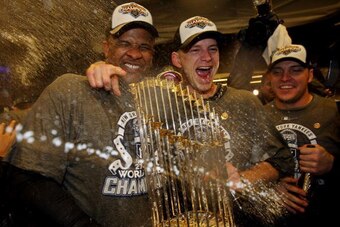 NEW YORK - NOVEMBER 04:  (L-R) C.C. Sabthia #52, A.J. Burnett #34 and Eric Hinske #14 of the New York Yankees celebrate with the trophy in the locker room after their 7-3 win against the Philadelphia Phillies in Game Six of the 2009 MLB World Series at Ya
