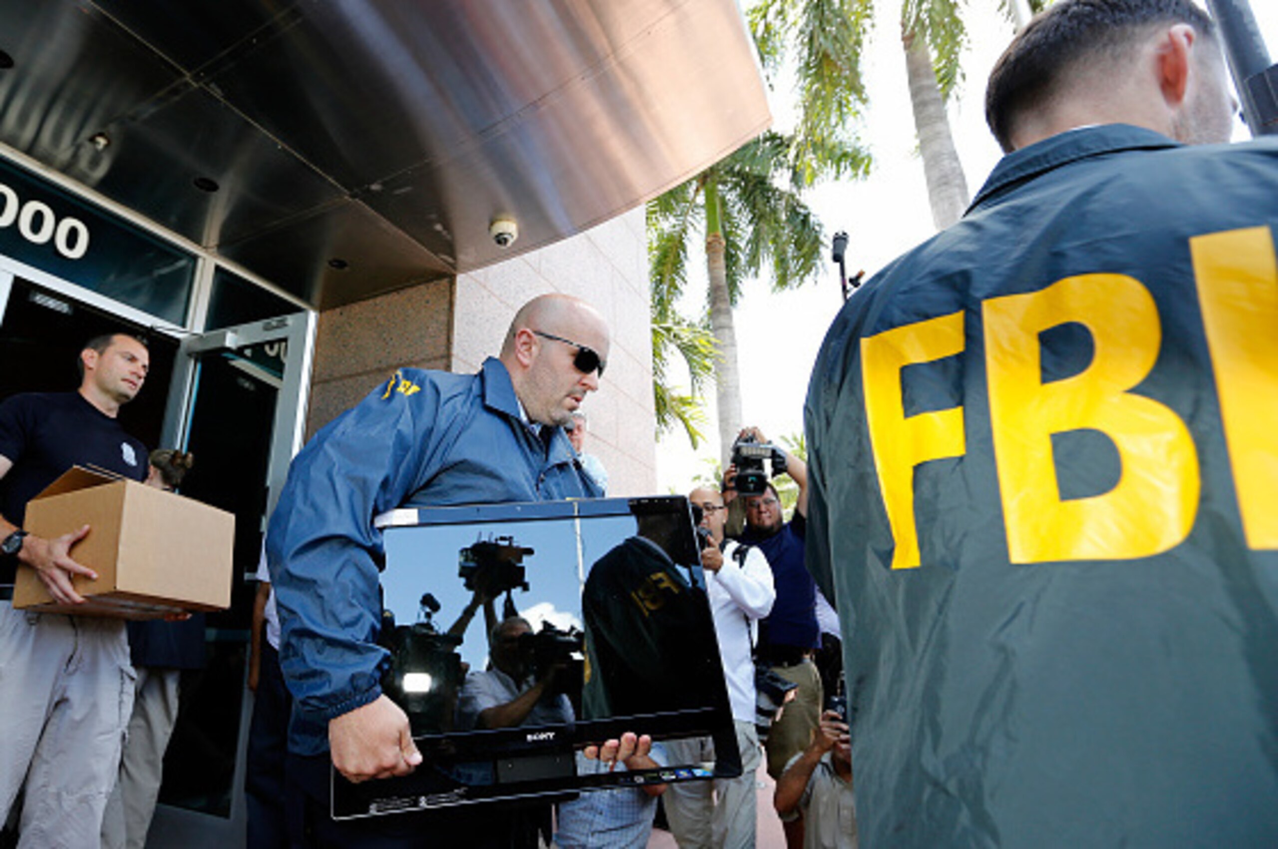 MIAMI BEACH, FL - MAY 27:  FBI agents carry boxes and computers from the headquarters of CONCACAF after it was raided on May 27, 2015 in Miami Beach, Florida. The raid is part of an international investigation of FIFA where nine FIFA officials and five co