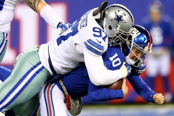 EAST RUTHERFORD, NJ - NOVEMBER 24:  Eli Manning #10 of the New York Giants is sacked by  Jason Hatcher #97 of the Dallas Cowboys at MetLife Stadium on November 24, 2013 in East Rutherford, New Jersey.  (Photo by Elsa/Getty Images)