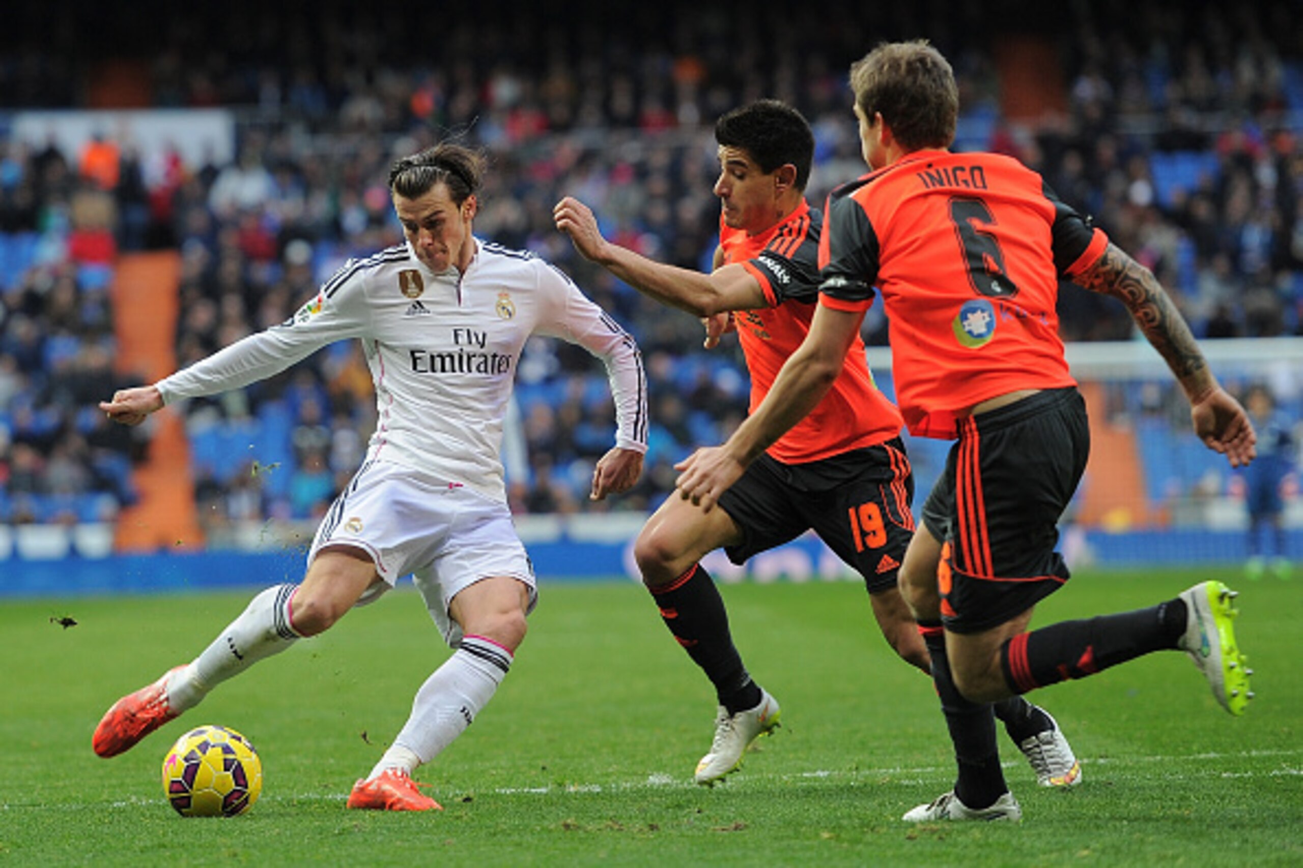 MADRID, SPAIN - JANUARY 31:  Gareth Bale of Real Madrid shoots past Yuri Berchiche (#19) and Inigo Martinez of Real Sociedad de Futbol  complains to the linesman during the La Liga match between Real Madrid CF and Real Sociedad de Futbol at Estadio Santia