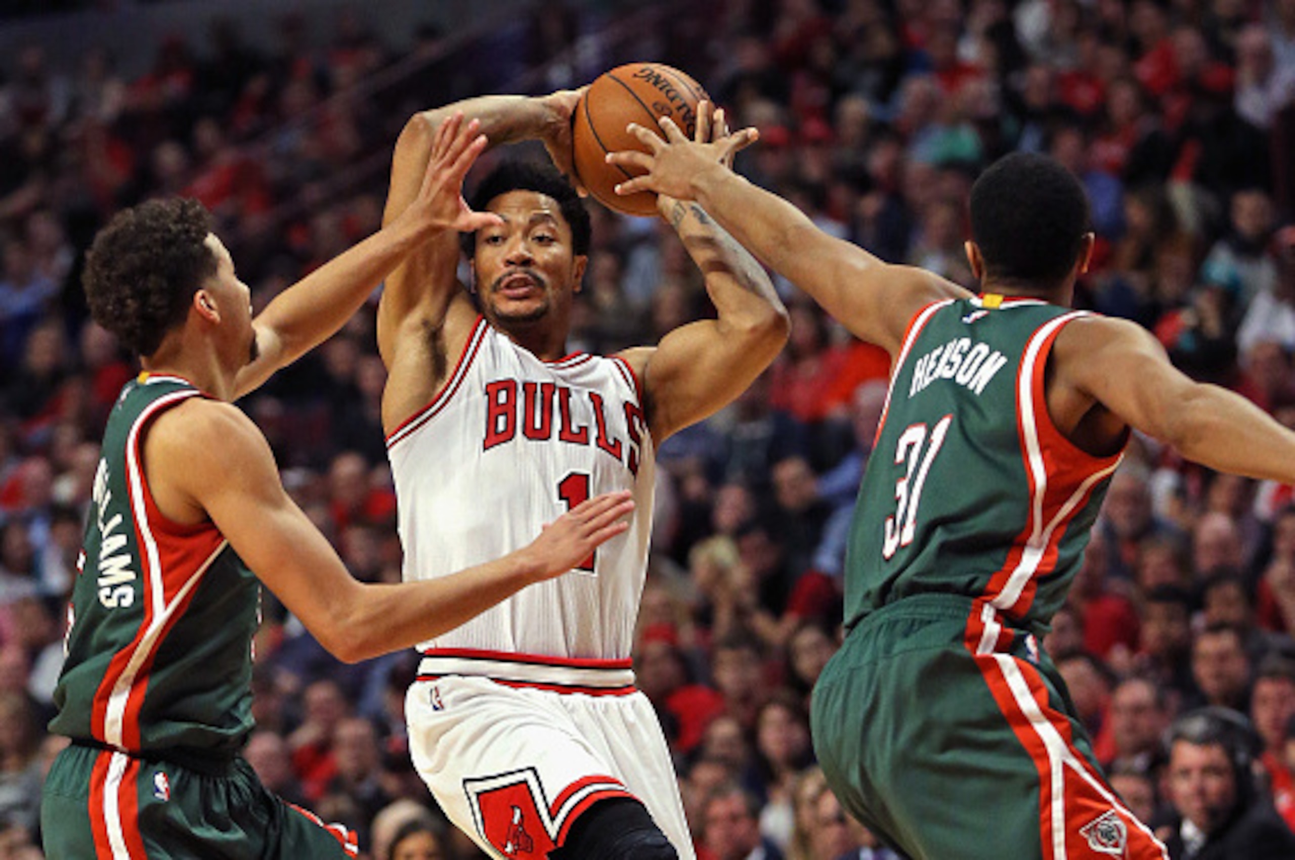 CHICAGO, IL - APRIL 27:  Derrick Rose #1 of the Chicago Bulls leaps to pass over Michael Carter-Williams #5 and John Henson #31 of the Milwaukee Bucks during the first round of the 2015 NBA Playoffs at the United Center on April 27, 2015 in Chicago, Illin