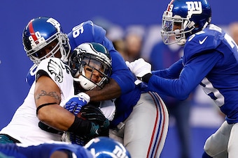 EAST RUTHERFORD, NJ - DECEMBER 28:  Chris Polk #32 of the Philadelphia Eagles carries the ball as  Jason Pierre-Paul #90 of the New York Giants defends during a game at MetLife Stadium on December 28, 2014 in East Rutherford, New Jersey.  (Photo by Jeff Z