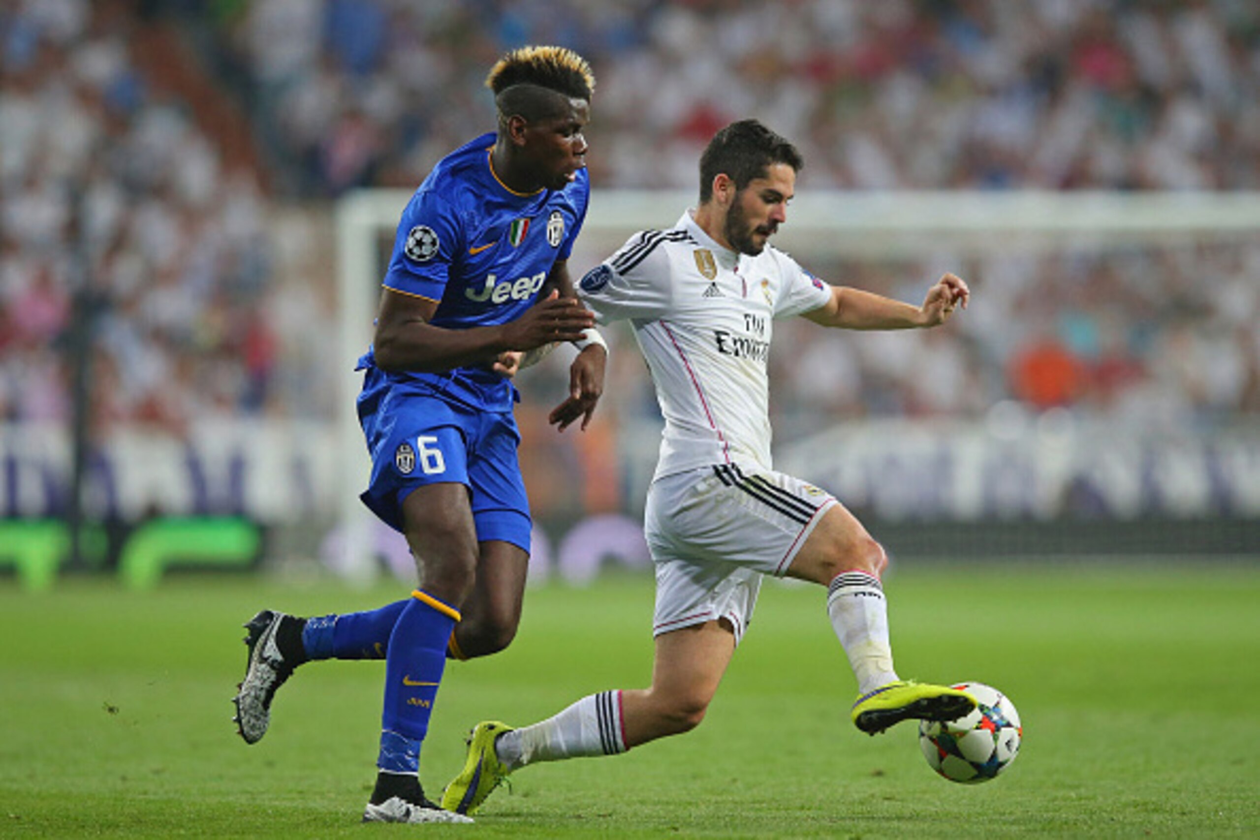 MADRID, SPAIN - MAY 13:  Isco of Real Madrid is challenged by Paul Pogba of Juventus during the UEFA Champions League Semi Final, second leg match between Real Madrid and Juventus at Estadio Santiago Bernabeu on May 13, 2015 in Madrid, Spain.  (Photo by A