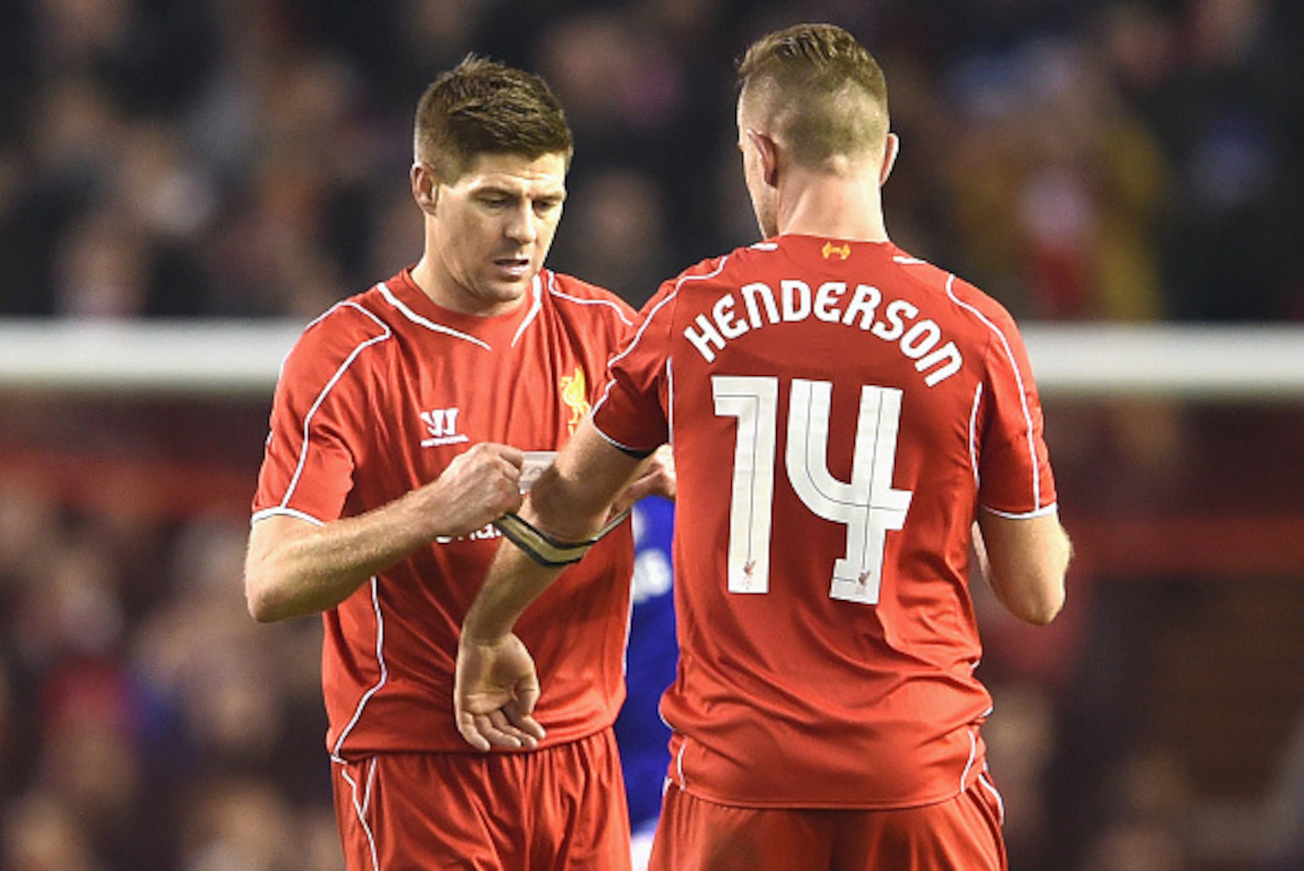 LIVERPOOL, ENGLAND - JANUARY 20:  Steven Gerrard of Liverpool hands the Captain's arm band over to Jordan Henderson of Liverpool during the Capital One Cup Semi-Final first leg match between Liverpool and Chelsea at Anfield on January 20, 2015 in Liverpoo