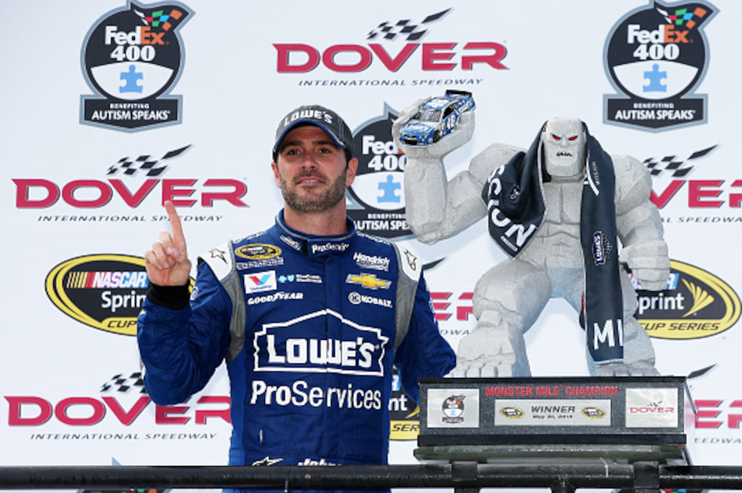 DOVER, DE - MAY 31:  Jimmie Johnson, driver of the #48 Lowe's Pro Services Chevrolet, poses with the Miles the Monster trophy in Victory Lane after winning the NASCAR Sprint Cup Series FedEx 400 Benefiting Autism Speaks at Dover International Speedway on 
