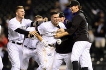 Jun 3, 2015; Denver, CO, USA; Colorado Rockies third baseman Nolan Arenado (center) is congratulated following his walk off sacrifice fly in the ninth inning against the Los Angeles Dodgers at Coors Field. The Rockies defeated the Dodgers 7-6. Mandatory C