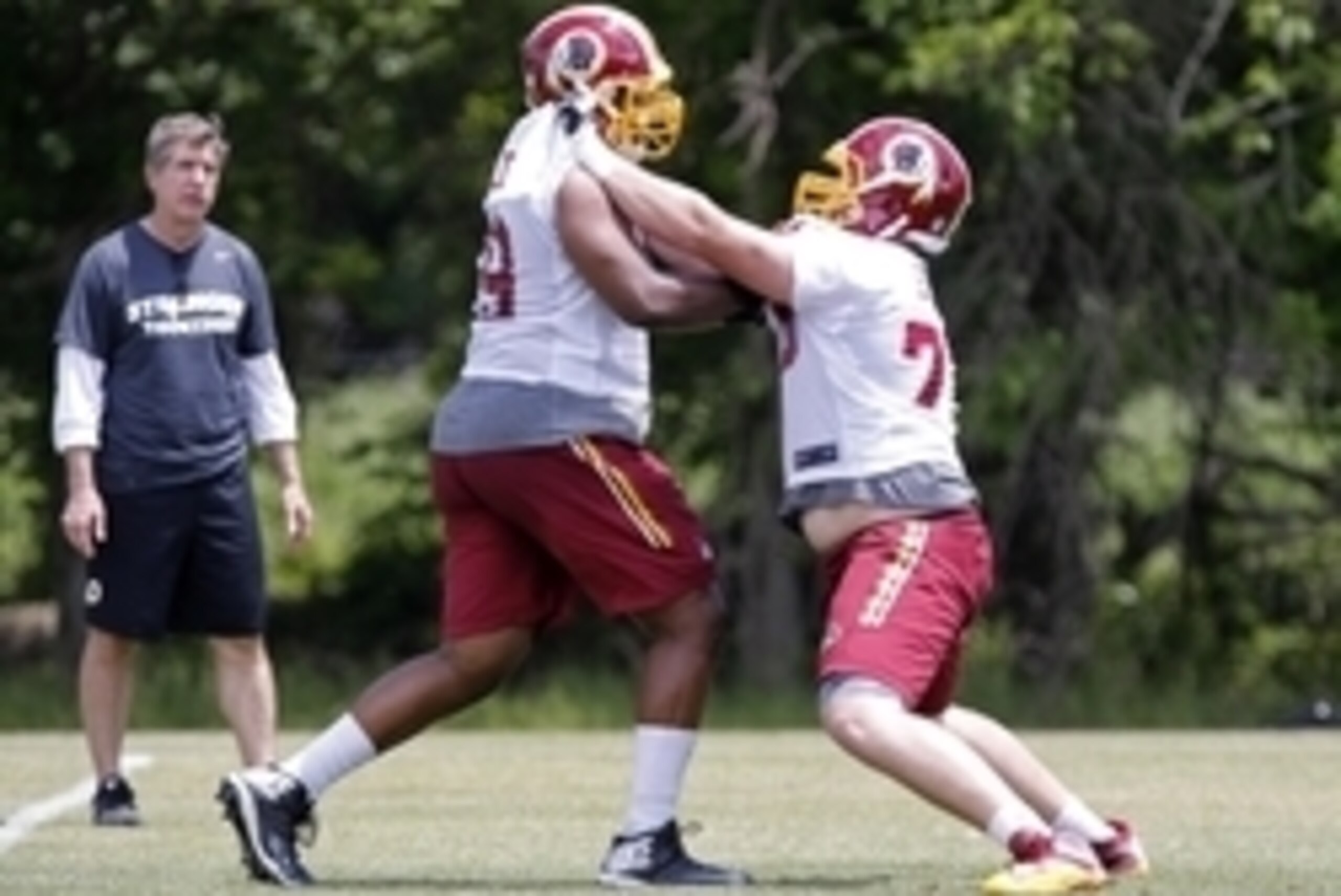 May 26, 2015; Ashbury, VA, USA; Washington Redskins offensive line coach Bill Callahan (L) looks on as Redskins offensive tackle Brandon Scherff (75) and Redskins tackle Takoby Cofield (69) participate in additional drills at the end of the Redskins OTA a