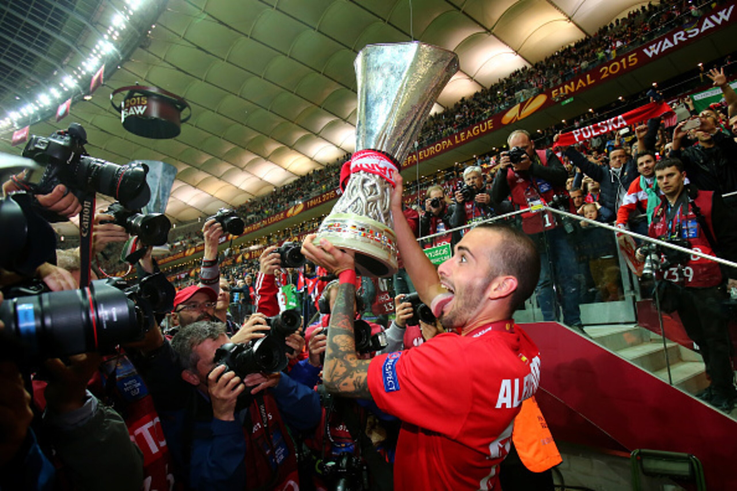 WARSAW, POLAND - MAY 27: Aleix Vidal of Sevilla lifts the trophy as he celebrates victory after the UEFA Europa League Final match between FC Dnipro Dnipropetrovsk and FC Sevilla on May 27, 2015 in Warsaw, Poland.  (Photo by Martin Rose/Getty Images)