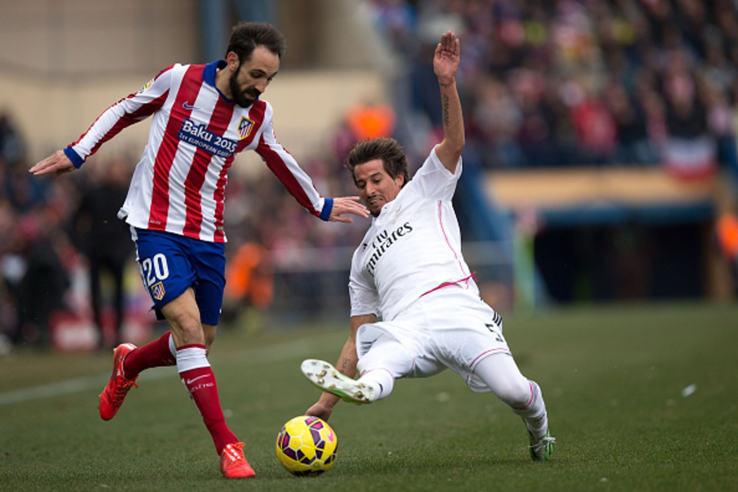 MADRID, SPAIN - FEBRUARY 07: Juan Francisco Torres alias Juanfran (L) of Atletico de Madrid competes for the ball with Fabio Coentrao (R) of Real Madrid CF during the La Liga match between Club Atletico de Madrid and Real Madrid CF at Vicente Calderon Sta