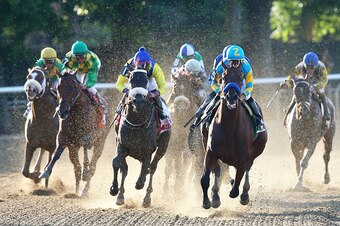 ELMONT, NY - JUNE 06:  American Pharoah #5, ridden by Victor Espinoza, leads the field out of the fourth turn during the 147th running of the Belmont Stakes at Belmont Park on June 6, 2015 in Elmont, New York.  (Photo by Elsa/Getty Images)