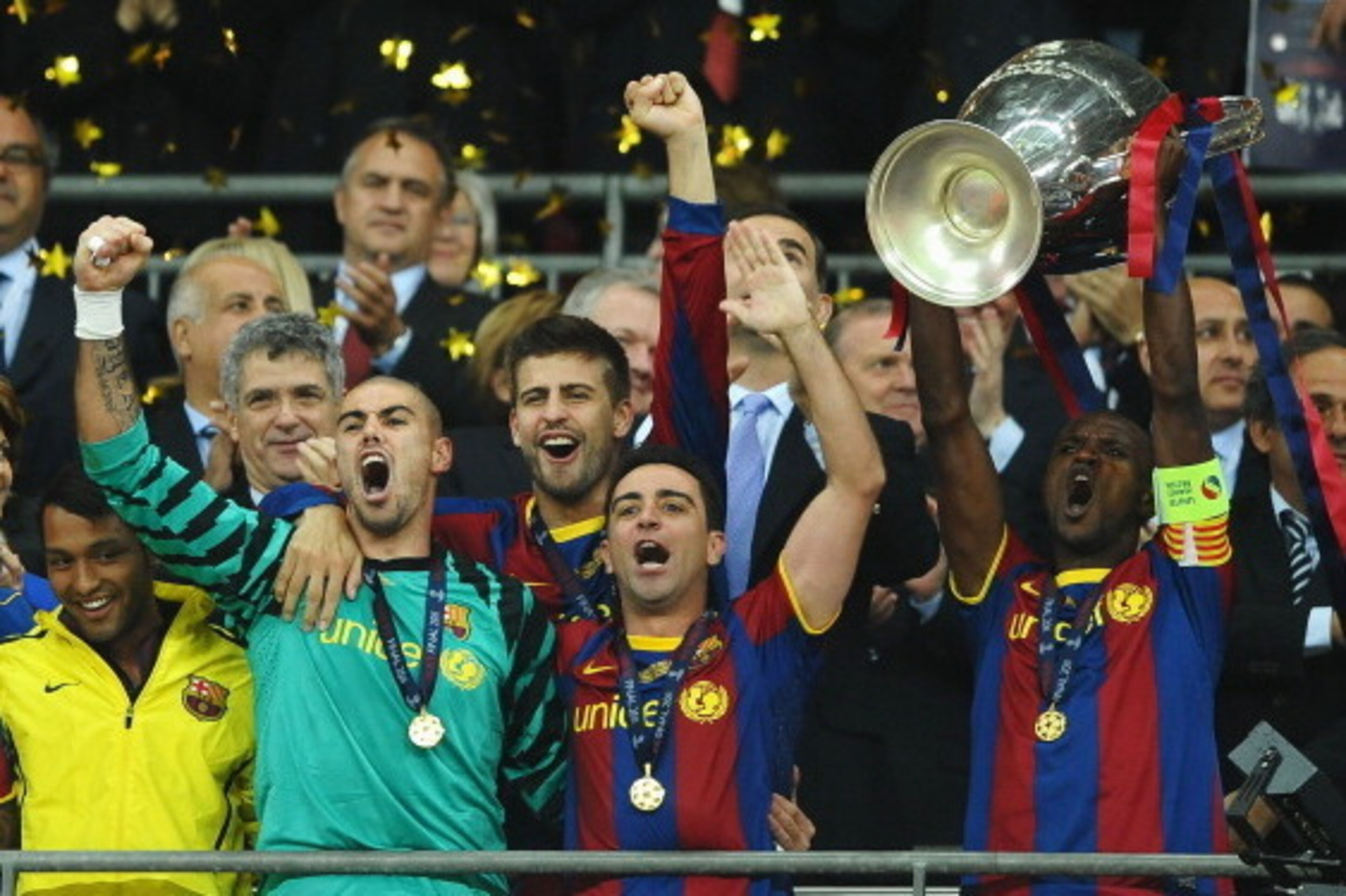 LONDON, ENGLAND - MAY 28:  Eric Abidal (R) of FC Barcelona lifts the trophy and celebrates with teammates Victor Valdes (2L), Xavi (2R) and Gerard Pique (behind) after victory in the UEFA Champions League final between FC Barcelona and Manchester United F