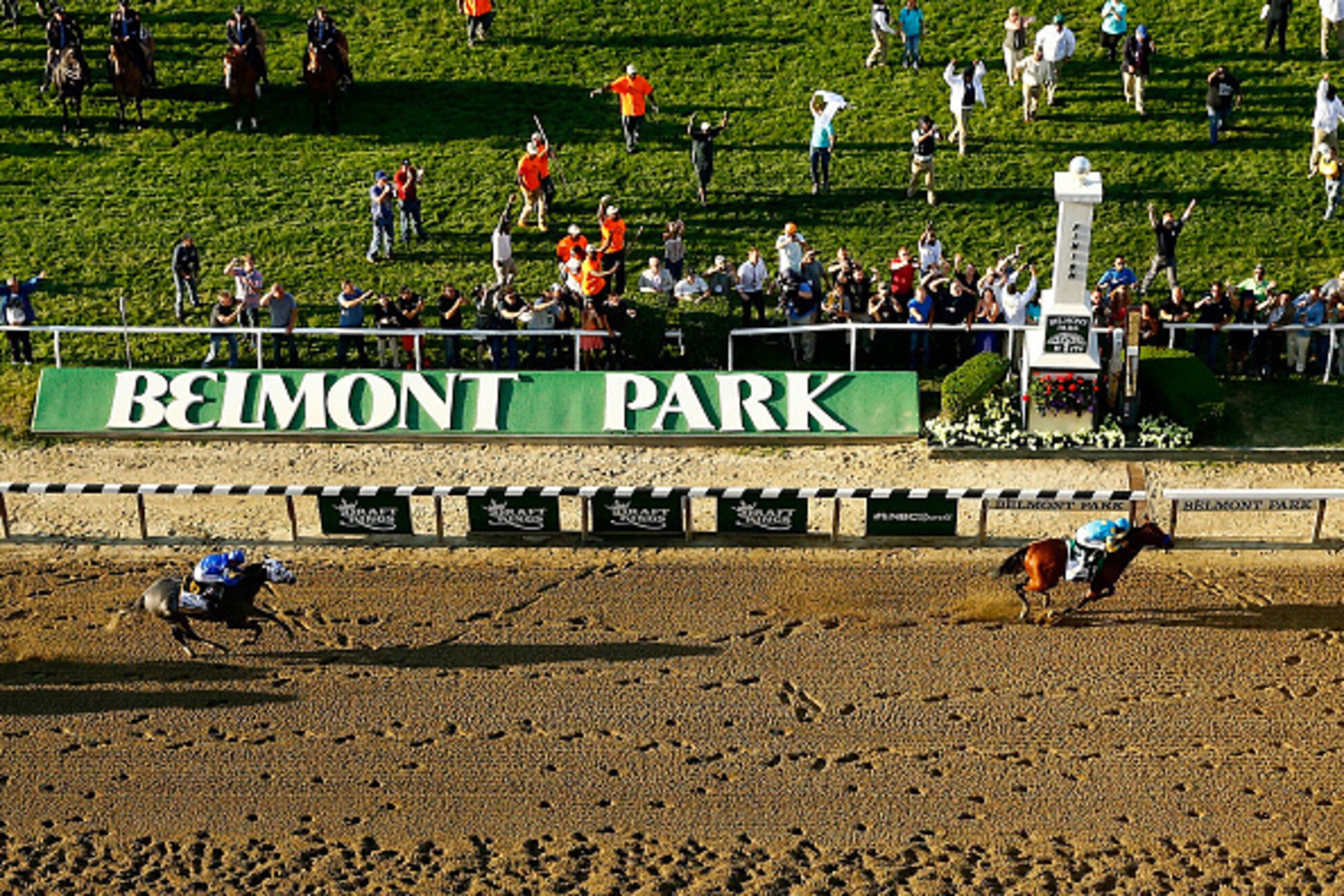 ELMONT, NY - JUNE 06:  American Pharoah #5, ridden by Victor Espinoza, crosses the finish line ahead of Frosted #6, ridden by Joel Rosario, to win the 147th running of the Belmont Stakes at Belmont Park on June 6, 2015 in Elmont, New York.  (Photo by Al B