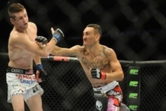 Aug 23, 2014; Tulsa, OK, USA; Max Holloway (red gloves) fights Clay Collard (blue gloves) in a Featherweight Bout at BOK Center. Mandatory Credit: Mark D. Smith-USA TODAY Sports