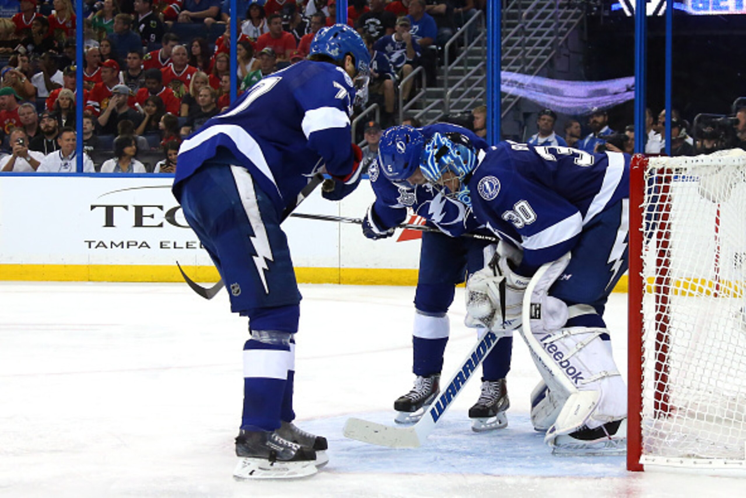 TAMPA, FL - JUNE 06:  Ben Bishop #30 of the Tampa Bay Lightning kneels over as he talks to teammates Victor Hedman #77 and Anton Stralman #6 of the Tampa Bay Lightning after a play at the net against the Chicago Blackhawks during the third period in Game 