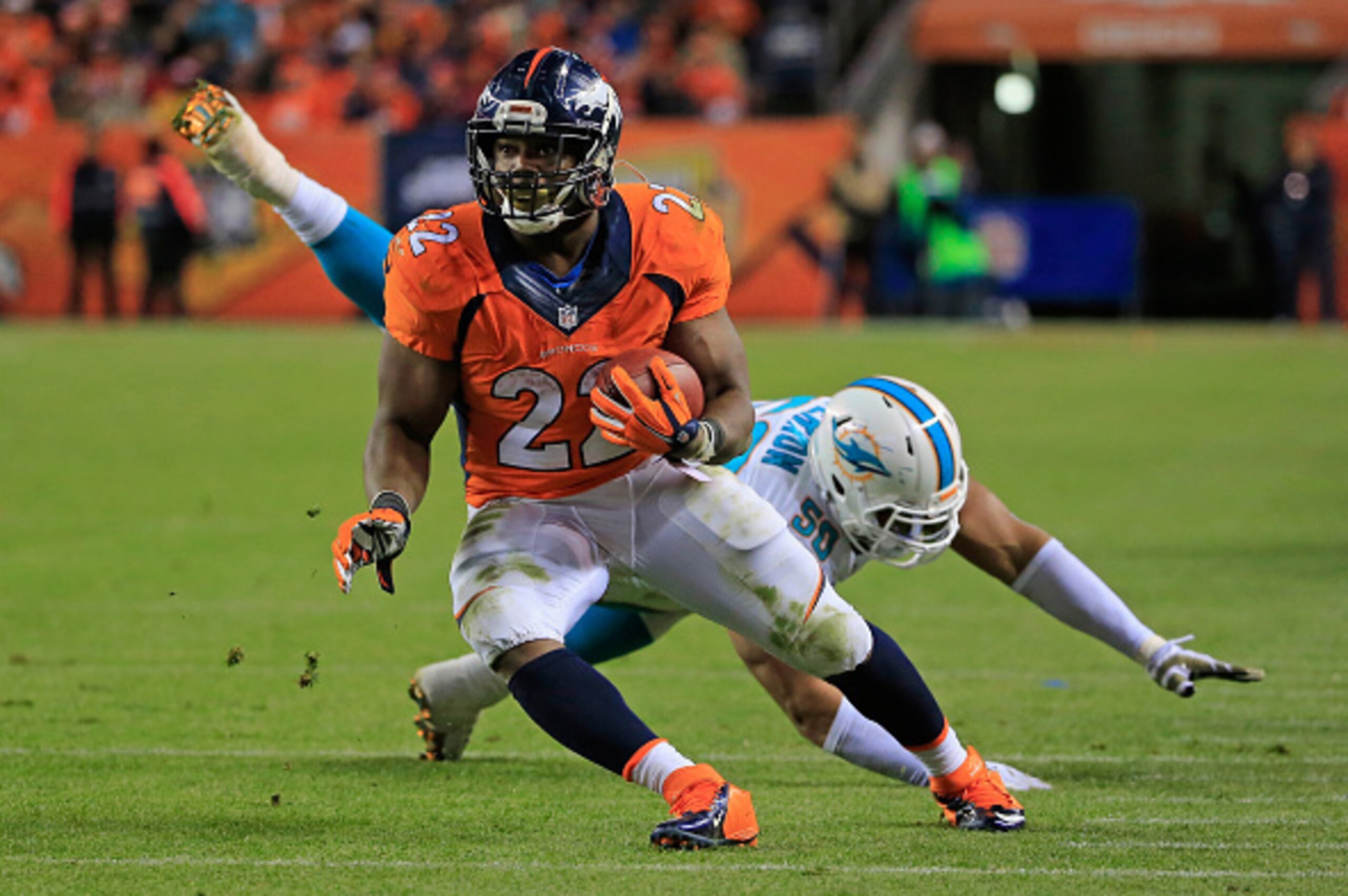 DENVER, CO - NOVEMBER 23:  Running back C.J. Anderson #22 of the Denver Broncos carries the ball and eludes defensive end Olivier Vernon #50 of the Miami Dolphins at Sports Authority Field at Mile High on November 23, 2014 in Denver, Colorado. The Broncos