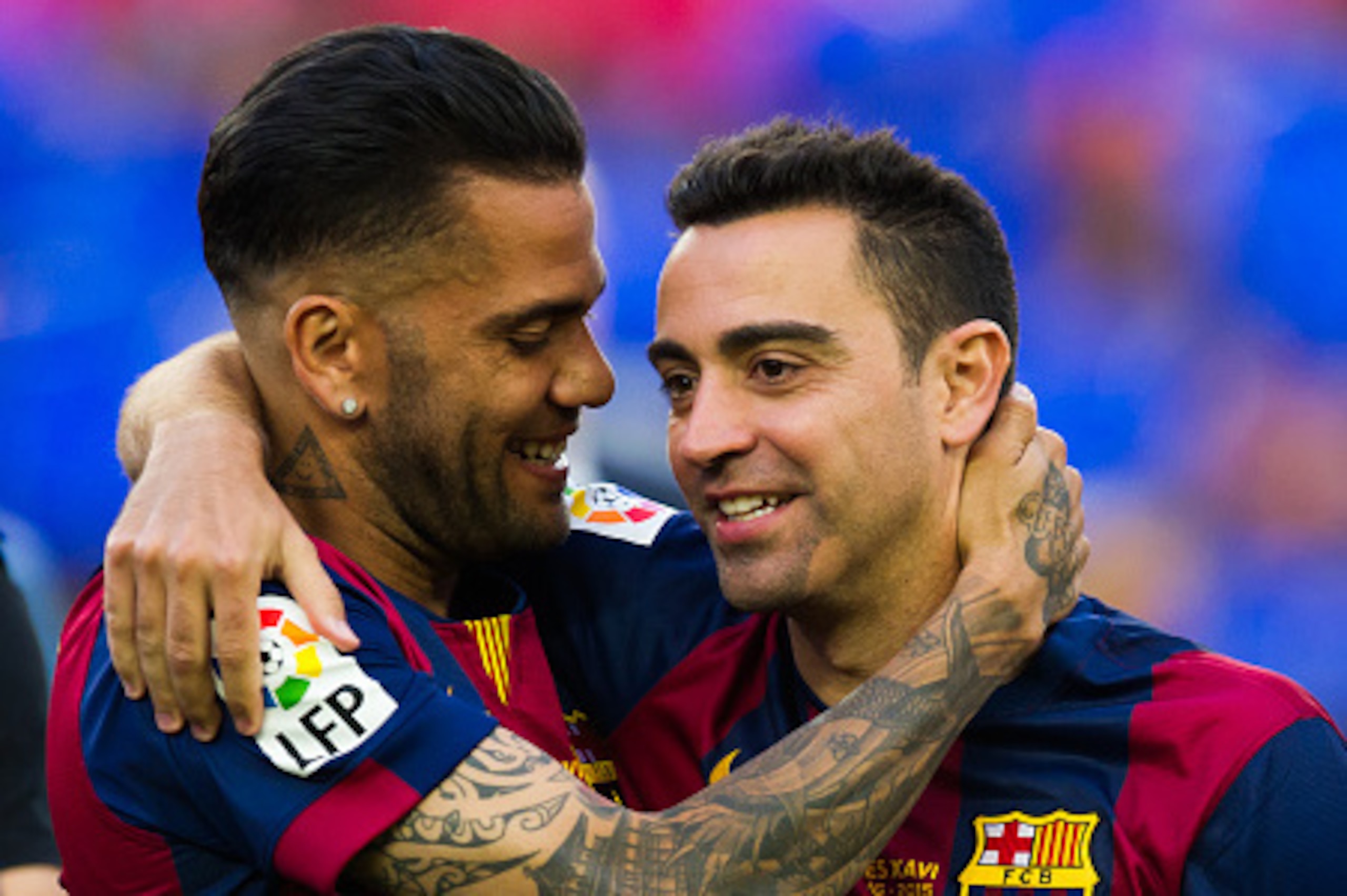 BARCELONA, SPAIN - MAY 23: Dani Alves (L) of FC Barcelona embraces his teammate Xavi Hernandez after the La Liga match between FC Barcelona and RC Deportivo La Coruna at Camp Nou on May 23, 2015 in Barcelona, Spain. (Photo by Alex Caparros/Getty Images)