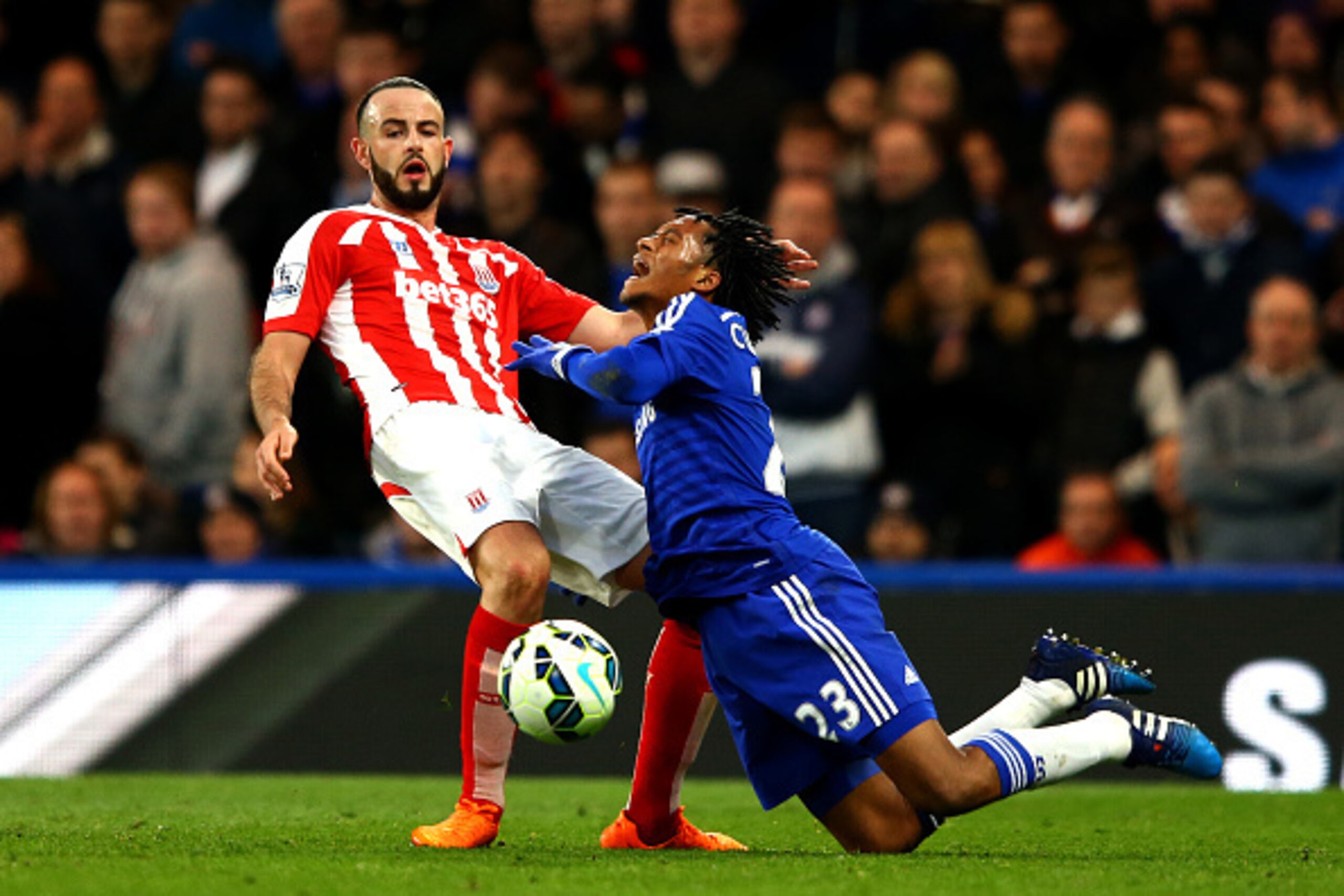 LONDON, ENGLAND - APRIL 04:  Juan Cuadrado of Chelsea battles for the ball with Marc Wilson of Stoke City during the Barclays Premier League match between Chelsea and Stoke City at Stamford Bridge on April 4, 2015 in London, England.  (Photo by Richard He
