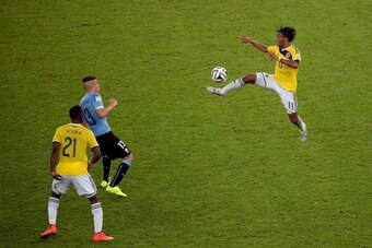 RIO DE JANEIRO, BRAZIL - JUNE 28: Juan Guillermo Cuadrado of Colombia controls the ball against Jose Gimenez of Uruguay during the 2014 FIFA World Cup Brazil round of 16 match between Colombia and Uruguay at Maracana on June 28, 2014 in Rio de Janeiro, Br